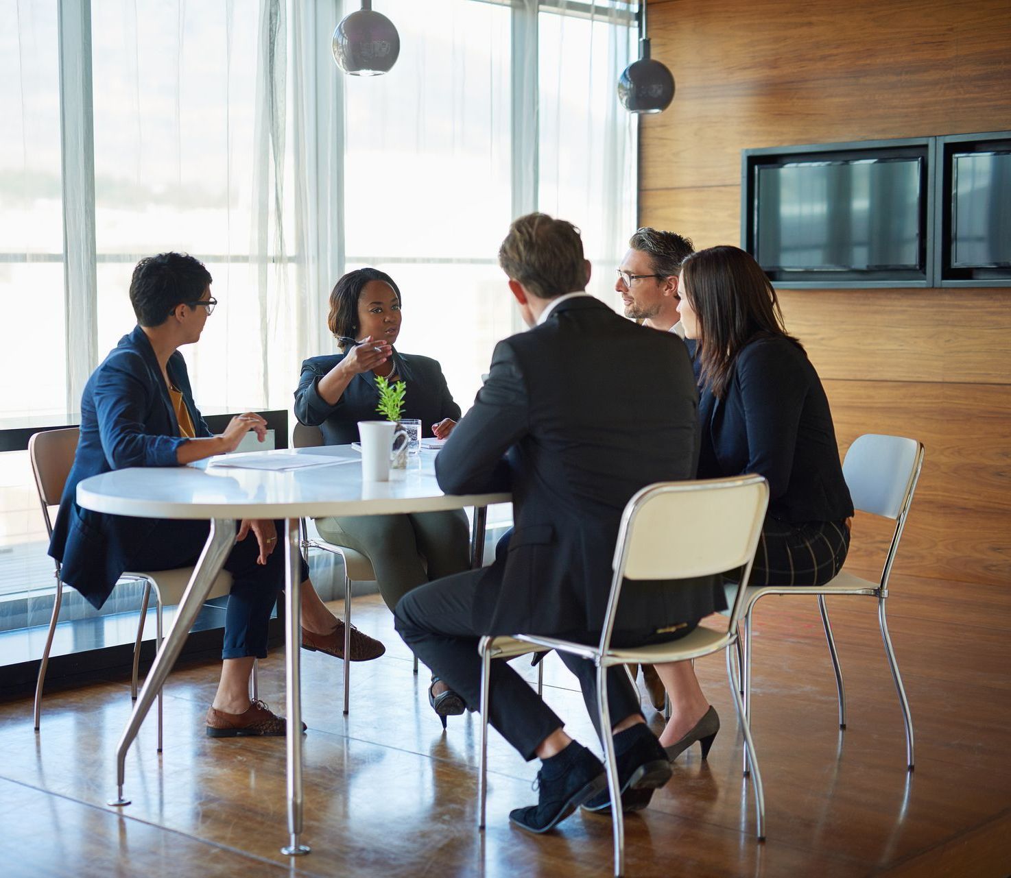 A group of dressed up staff members having a meeting at a table