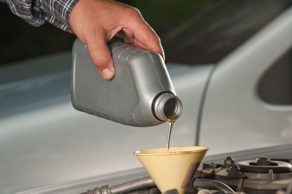 Man Hand pouring Oil — A Grade Oils & Batteries In Wangaratta VIC
