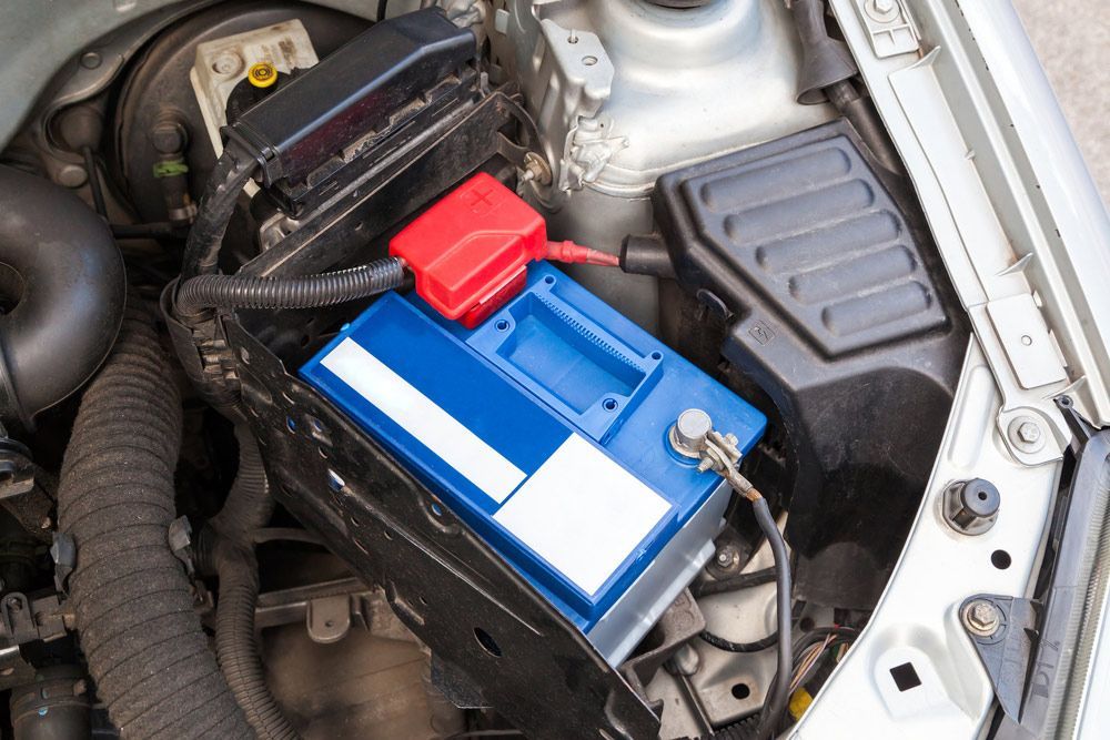 New blue Car battery in engine room — A Grade Oils & Batteries In Wodonga VIC