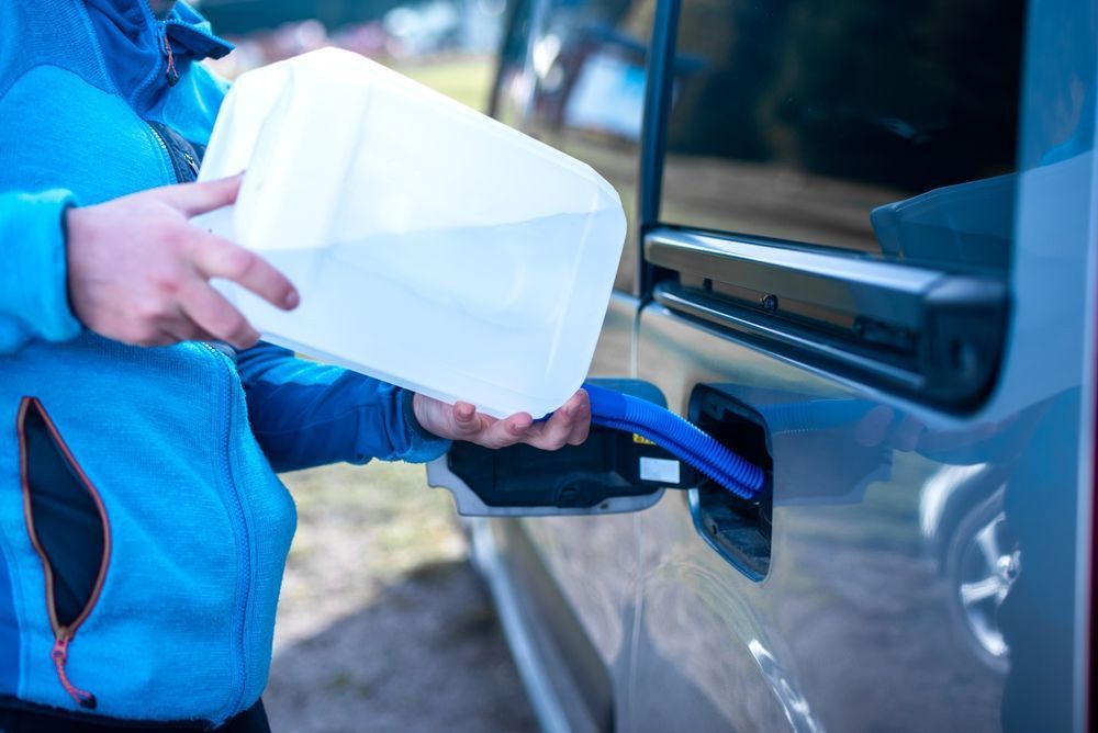 Pouring adblue fluid to the car — A Grade Oils & Batteries In Wagga Wagga NSW