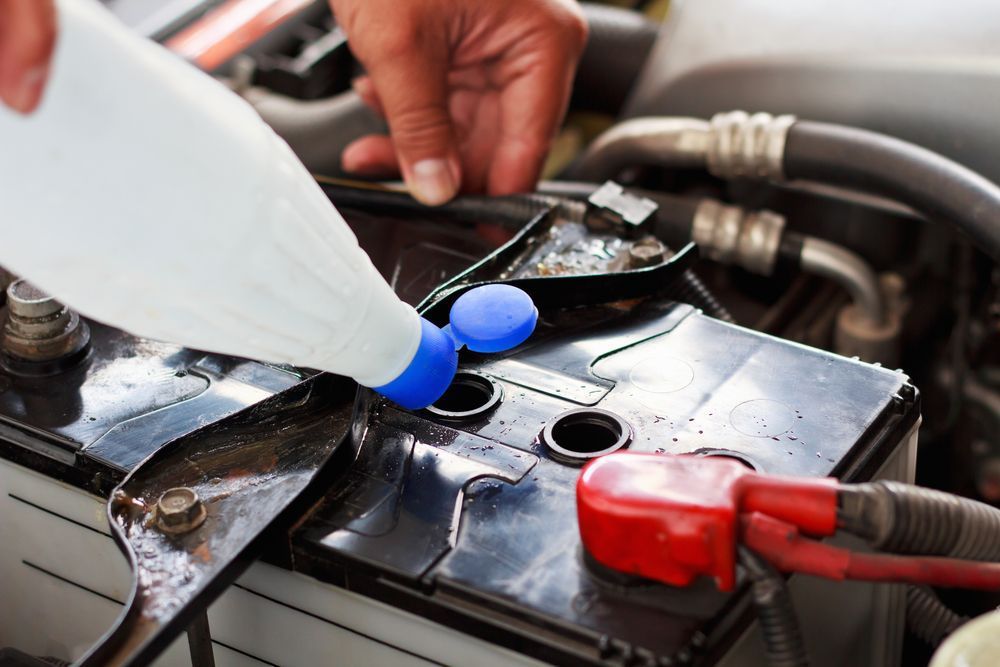 Mechanic added fluid to the battery of a car — A Grade Oils & Batteries In Myrtleford VIC