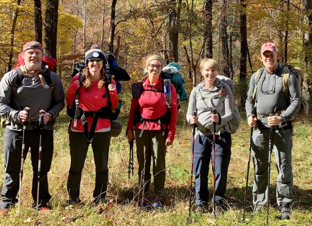 A group of people standing next to each other in the woods.