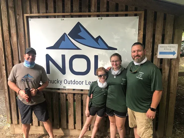 A group of people standing in front of a sign that says noi.