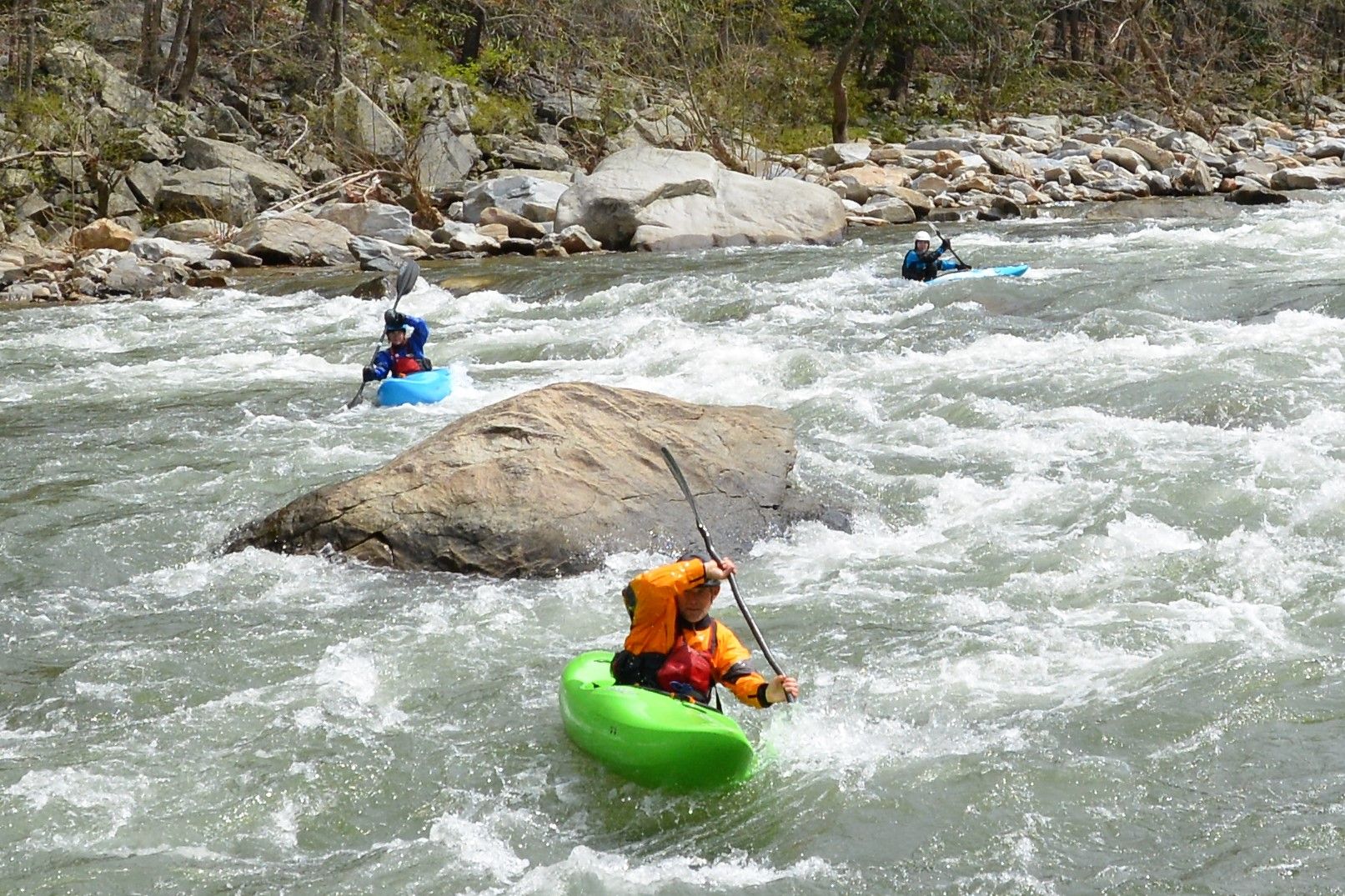 A group of people are kayaking down a river.