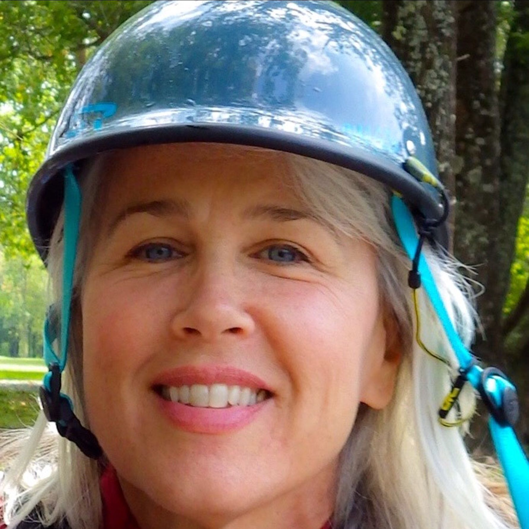 A woman wearing a helmet is smiling for the camera