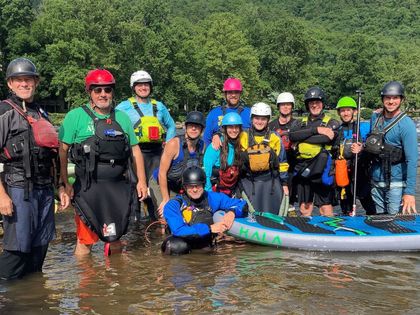 A group of people are posing for a picture in the water.