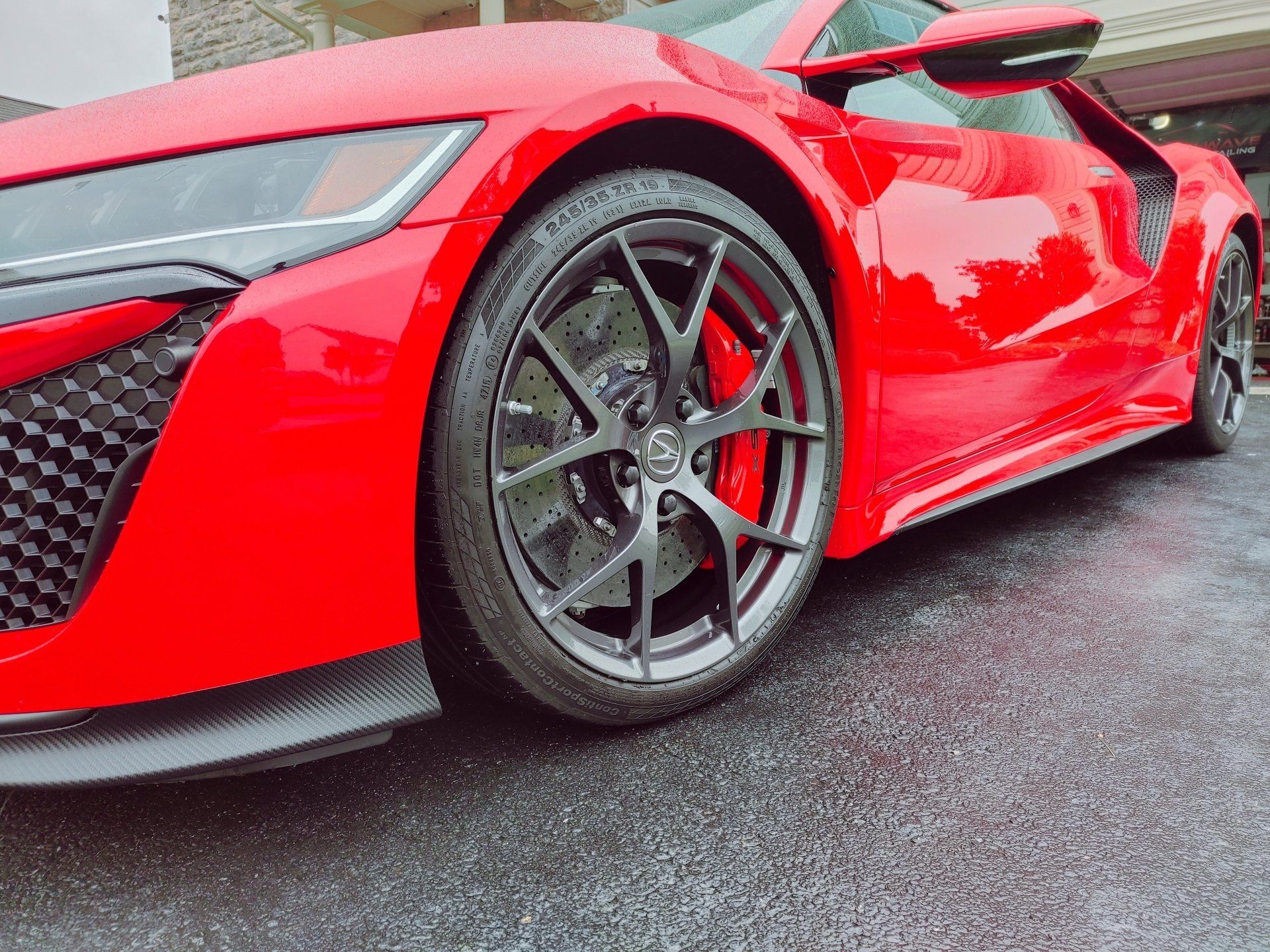 a red sports car is parked in a driveway in front of a house .