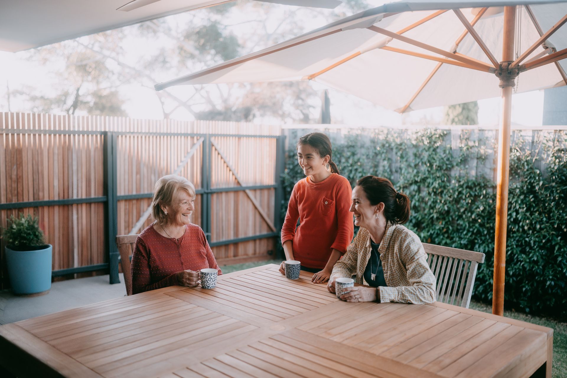 Grandmother enjoying tea with her family in the patio. Grandmother enjoying tea with her family in the patio.