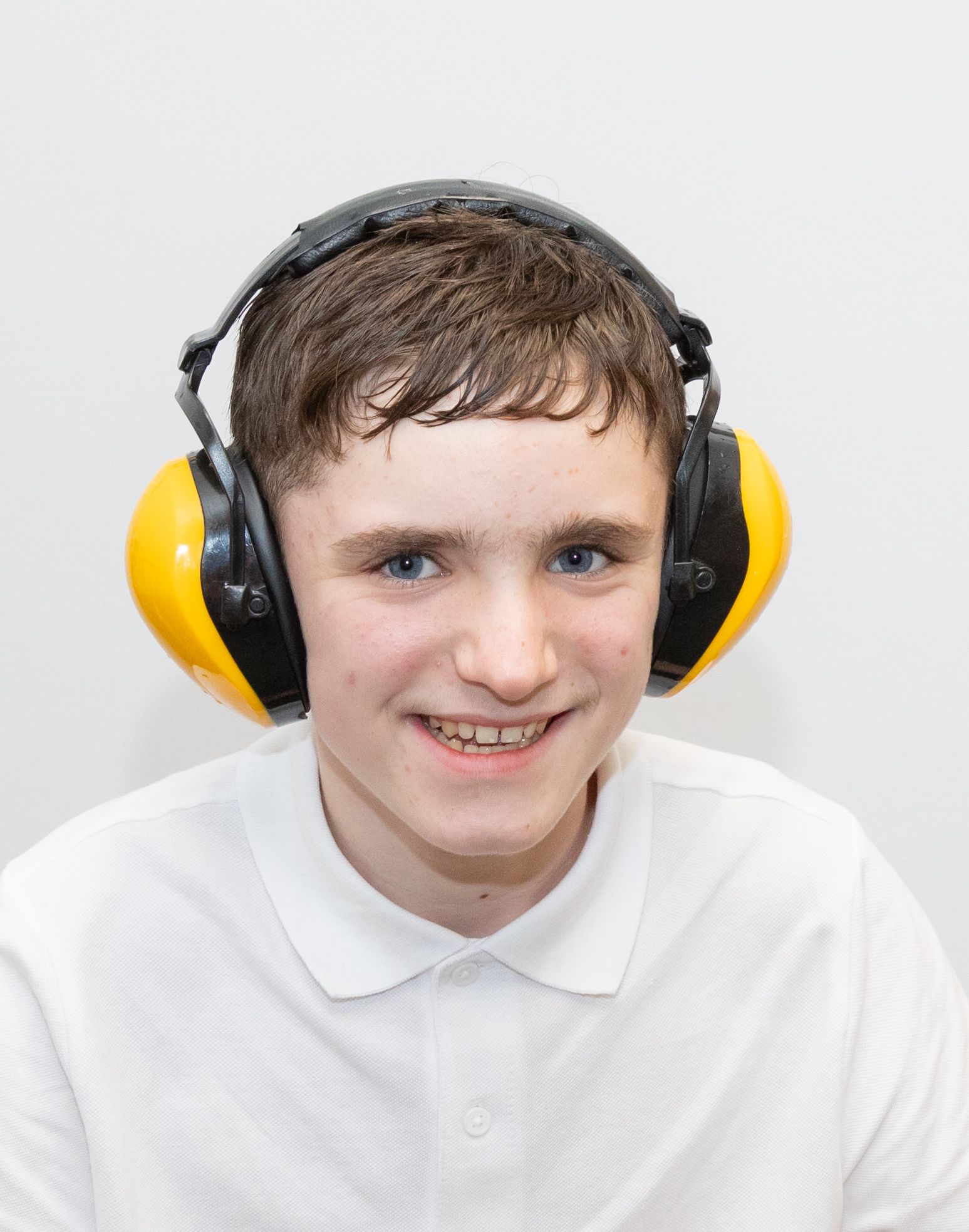 Harry is wearing headphones and is smiling.