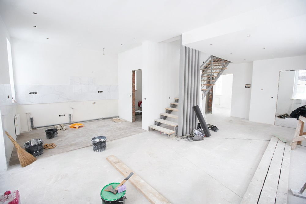 a living room under construction with a staircase in the middle of the room .