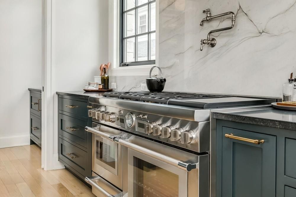 a kitchen with stainless steel appliances and blue cabinets .