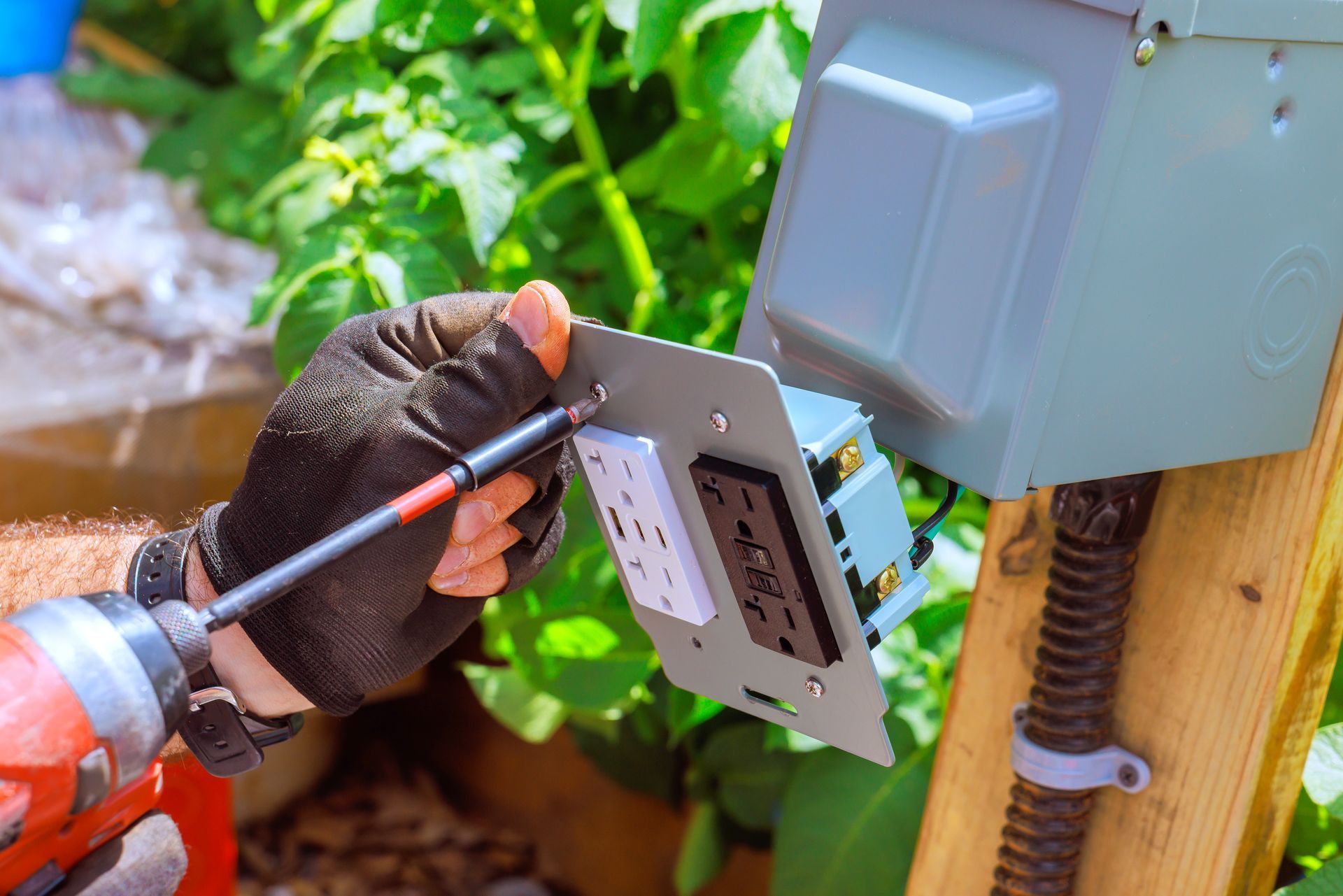 Close-up of electrician installing outdoor GFCI outlet on residential electrical box in Weatherford,