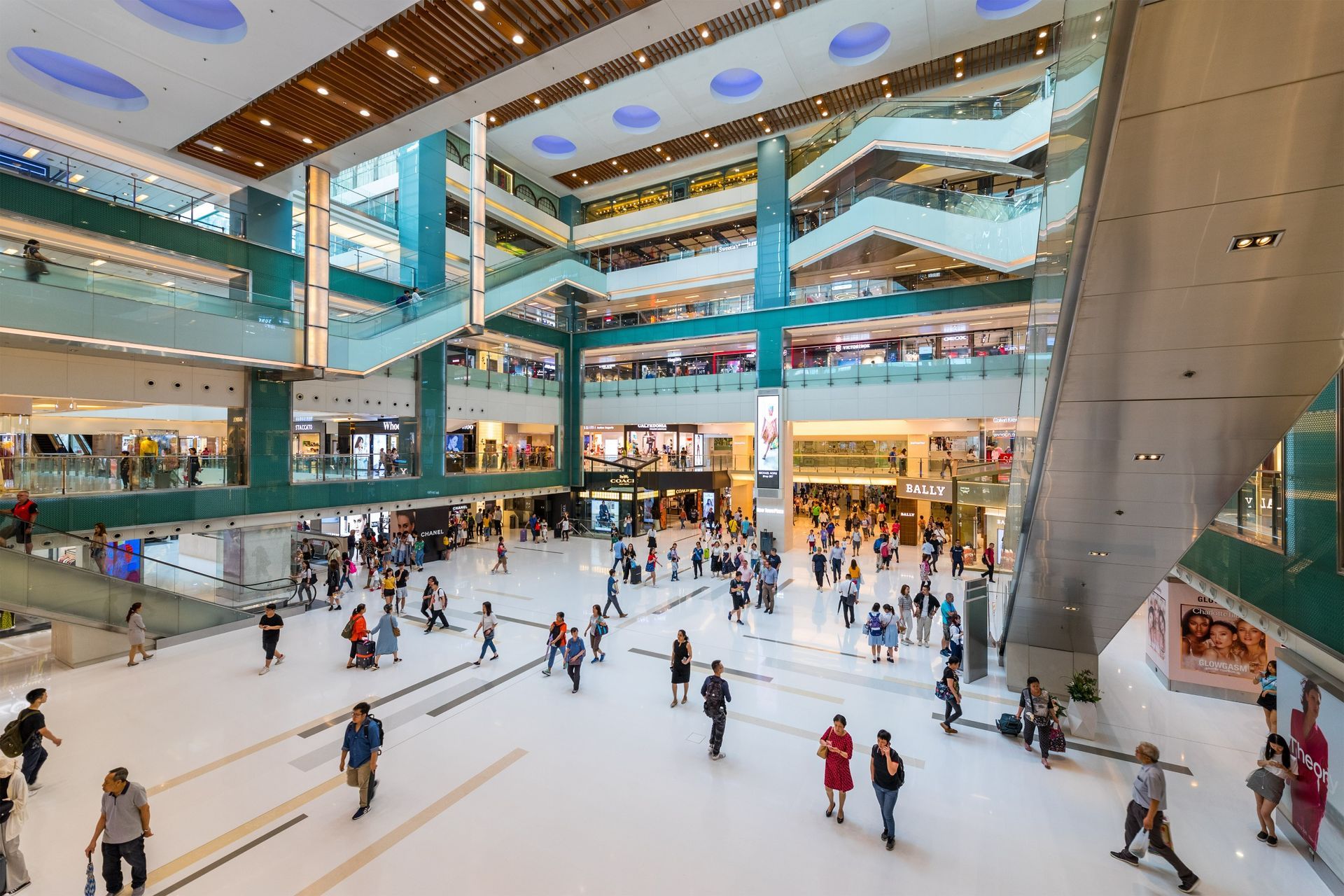A group of people are ice skating in a large mall.