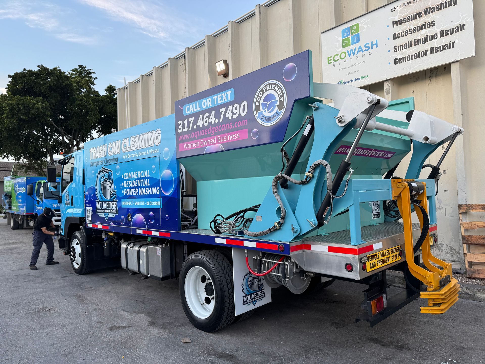 A garbage truck is parked in front of a building.