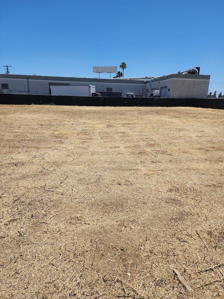 An empty field with a building in the background