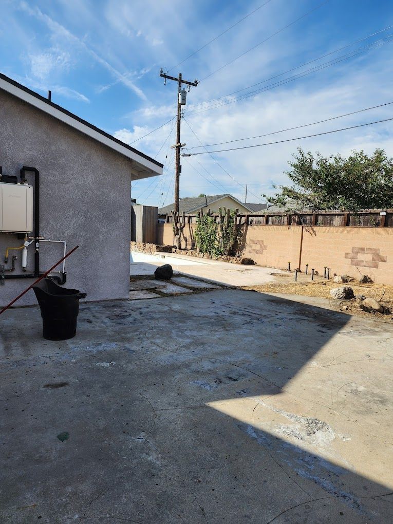 A backyard with a house and a trash can