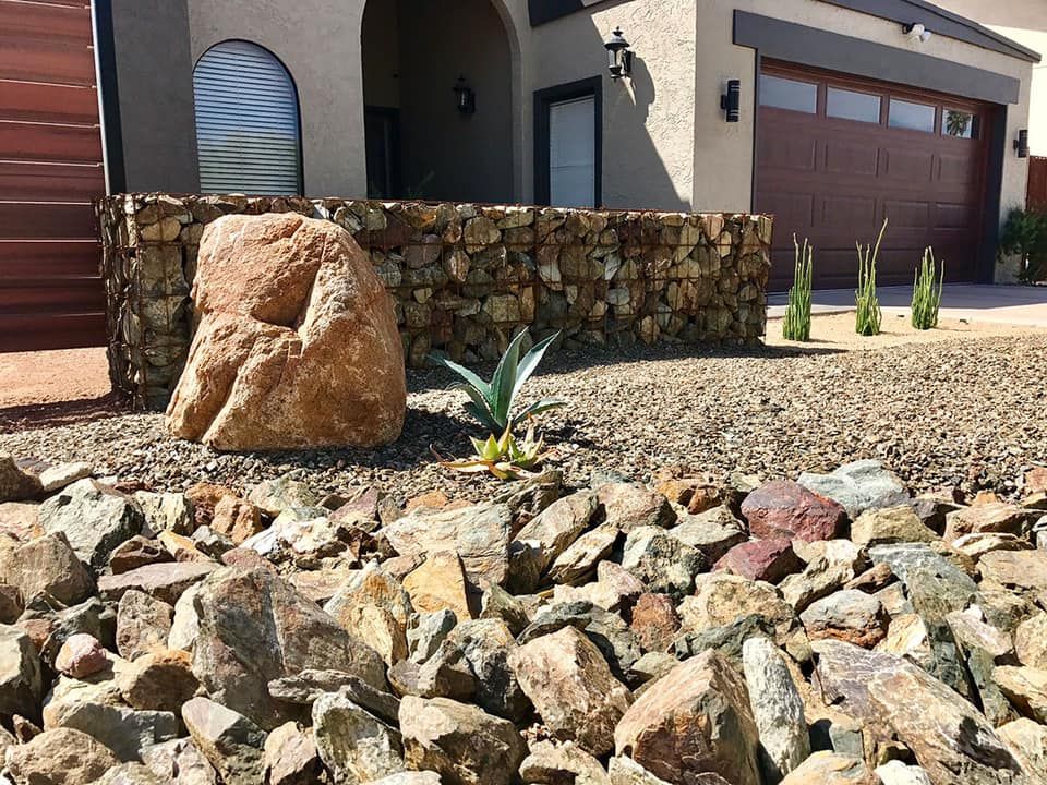 A large rock is sitting in front of a house.