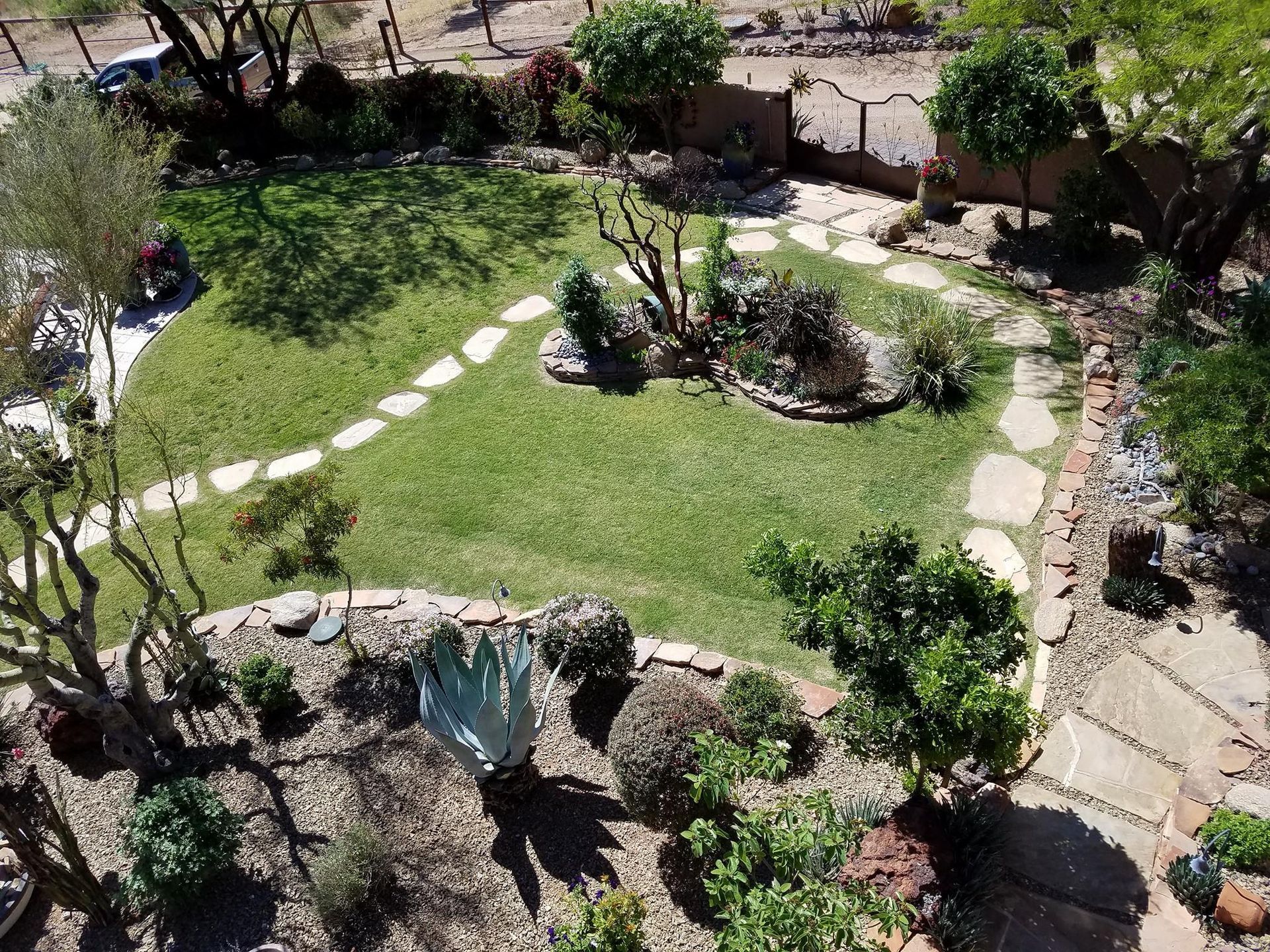 An aerial view of a lush green garden with a stone walkway.
