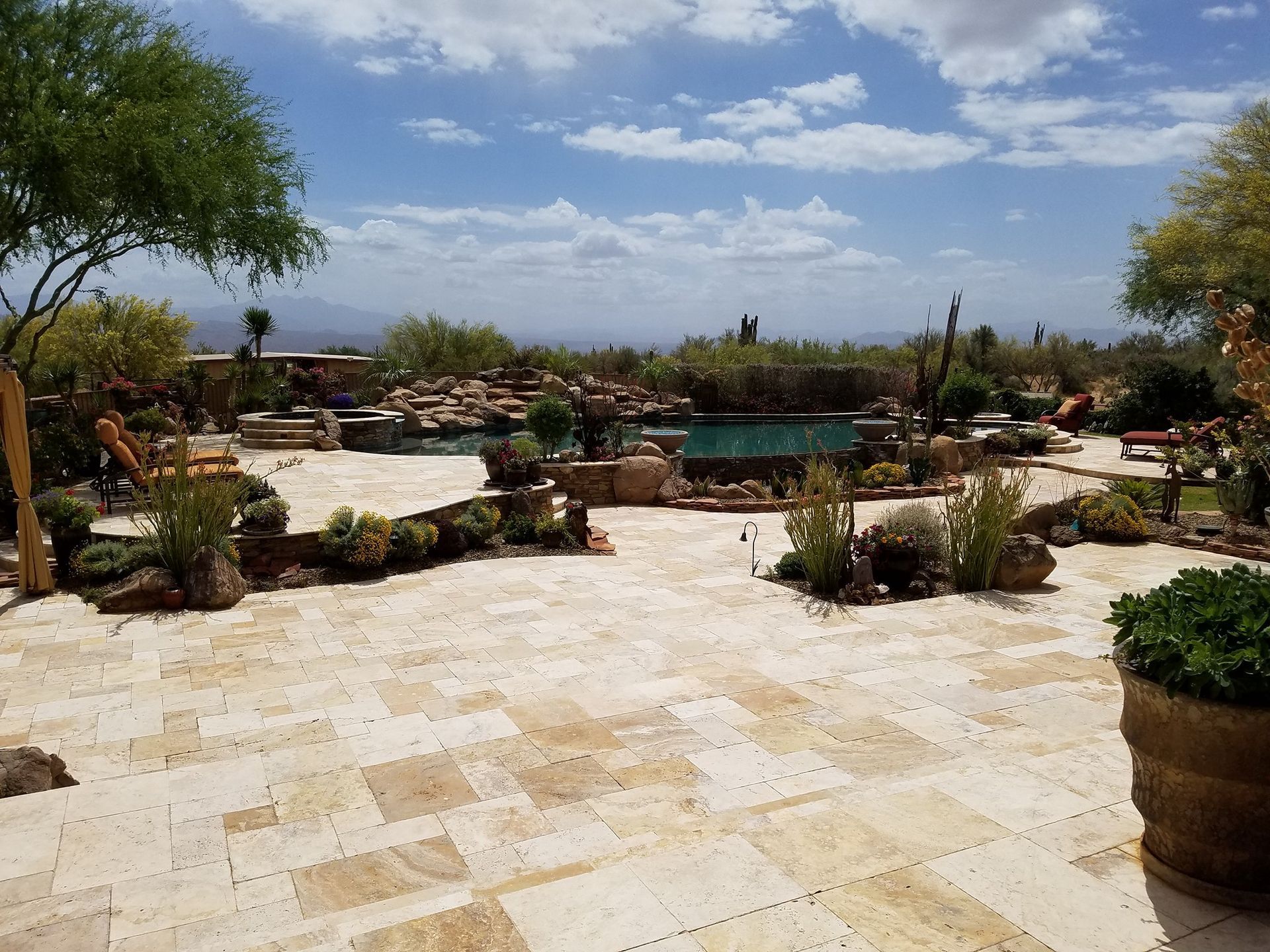 A large patio with a swimming pool in the background