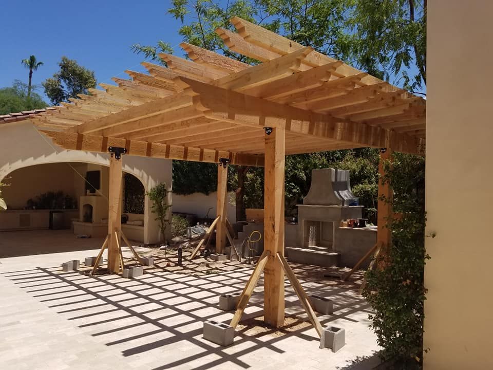 A wooden pergola is being built in front of a house