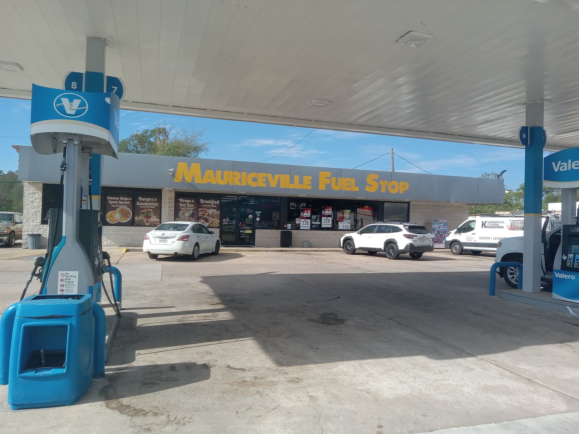 A gas station with cars parked in front of it