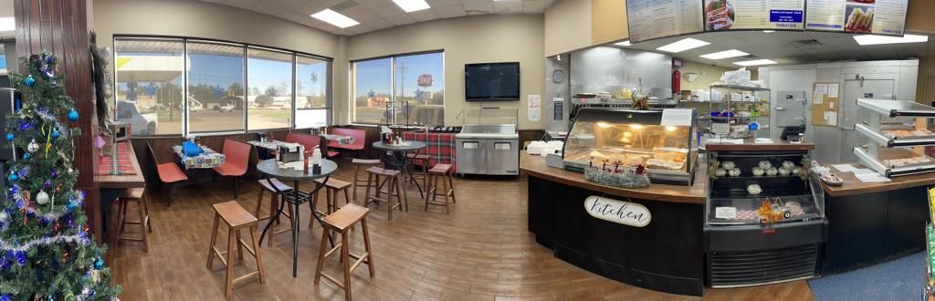 A restaurant with a christmas tree in the middle of the room.