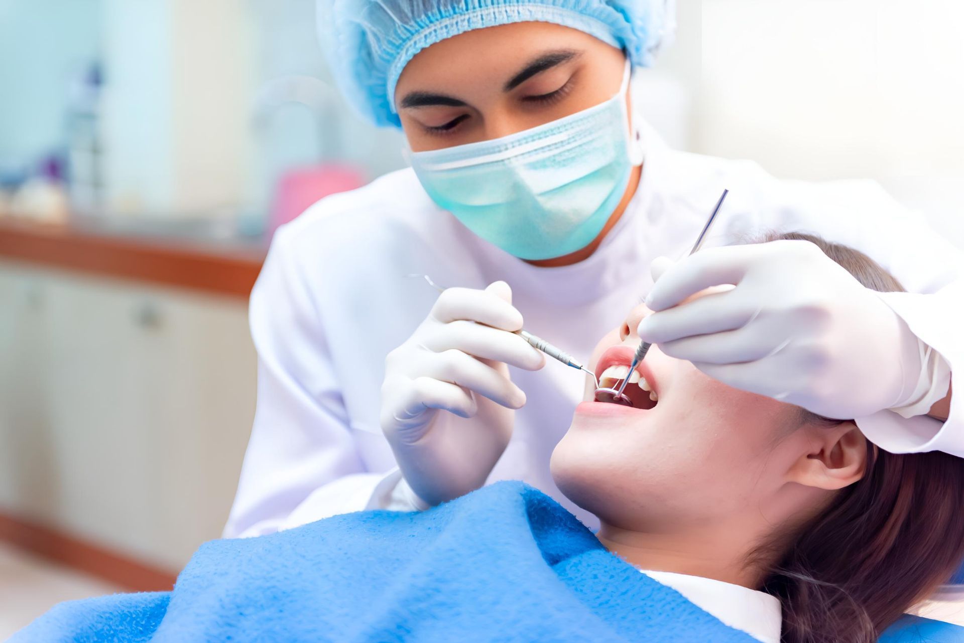 A Dentist is Examining a Woman's Teeth in a Dental Office — Trower Dental In Palmerston, NT