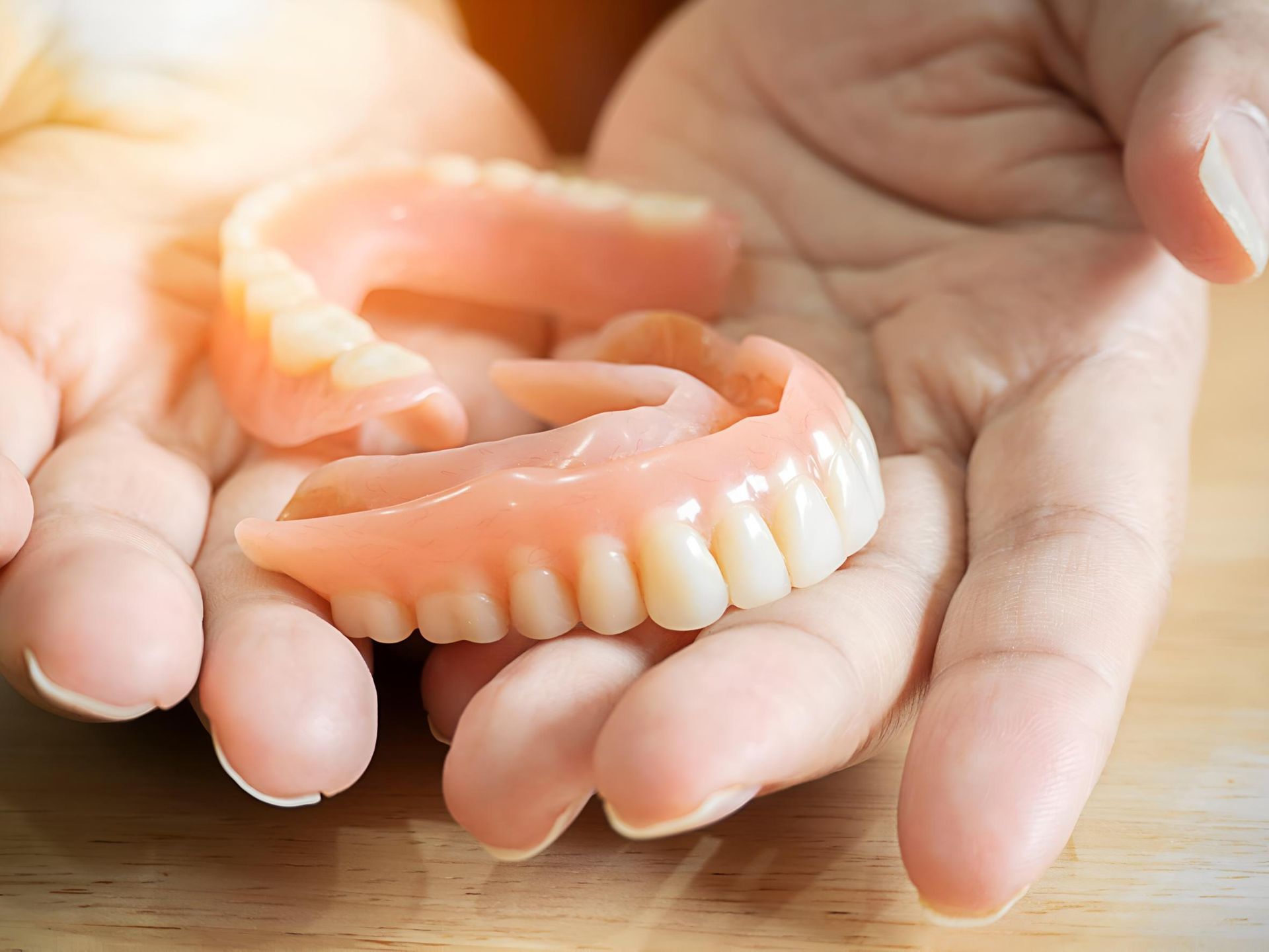 A Person is Holding a Full Denture in Their Hands — Trower Dental In Casuarina, NT