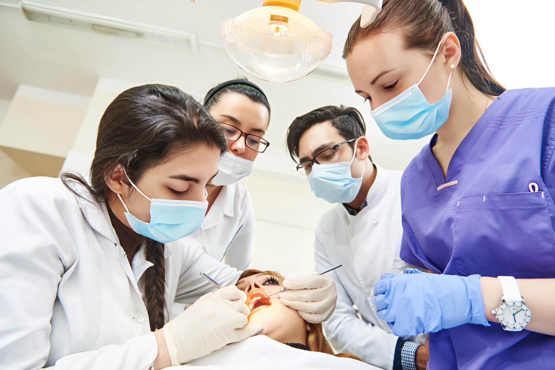 A Group of Dentists Are Working on a Patient in a Dental Office — Trower Dental In Casuarina, NT