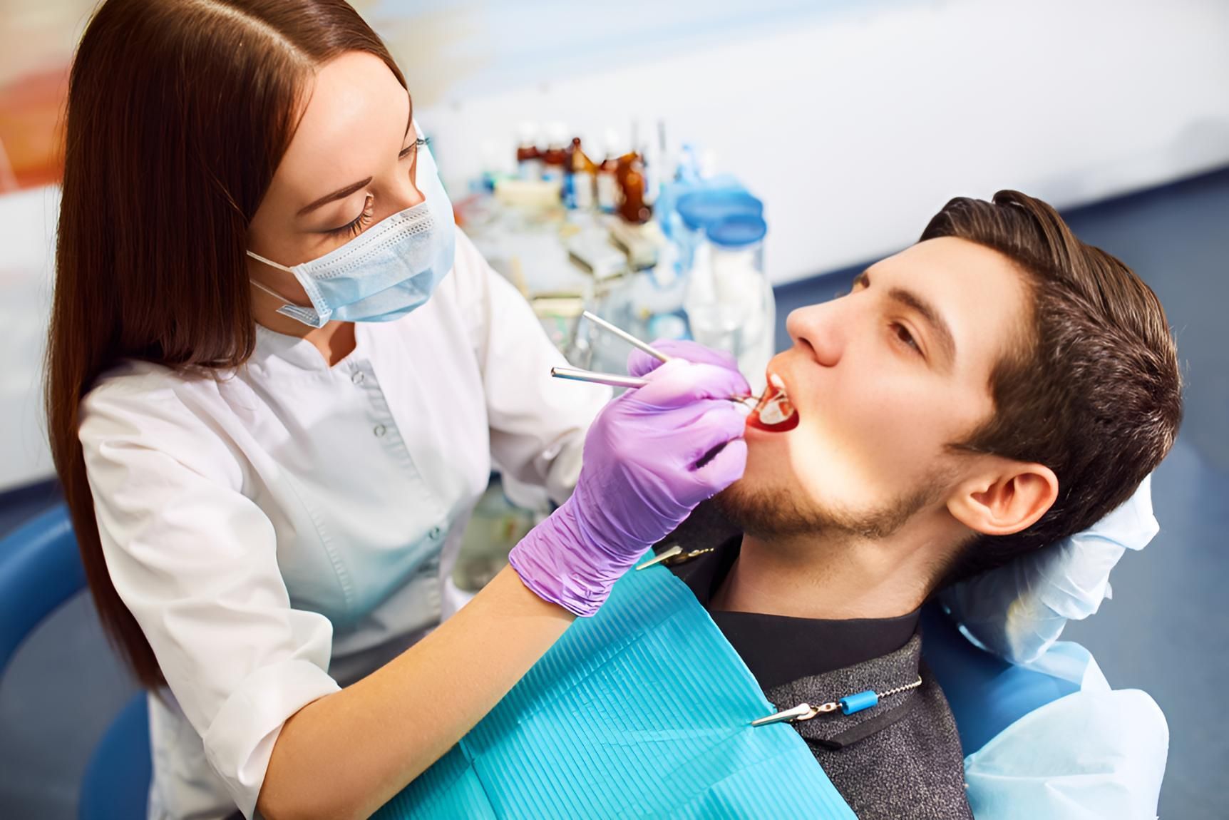 A Man is Getting His Teeth Examined by a Female Dentist — Trower Dental In Palmerston, NT