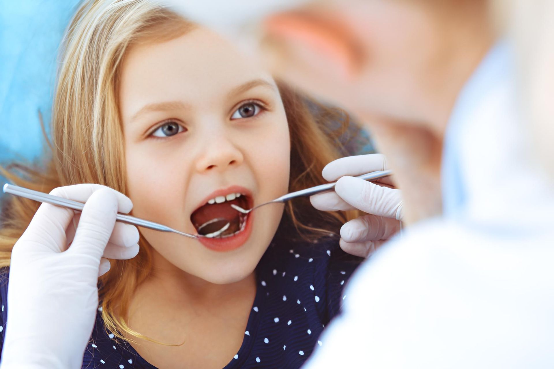 A Little Girl is Getting Her Teeth Examined by a Dentist — Trower Dental In Palmerston, NT