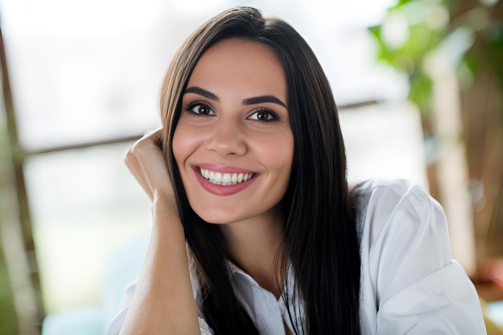 A Close Up of a Woman Smiling With Her Hand on Her Chin — Trower Dental In Casuarina, NT