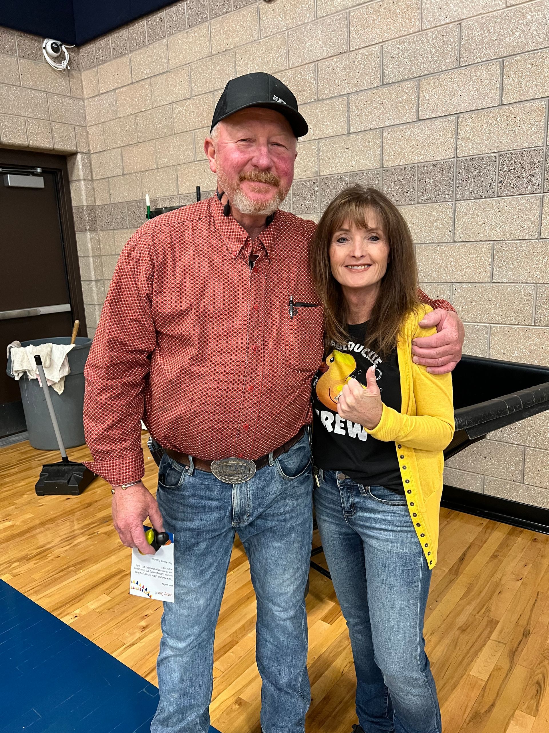 A man and a woman are standing next to each other on a wooden floor.