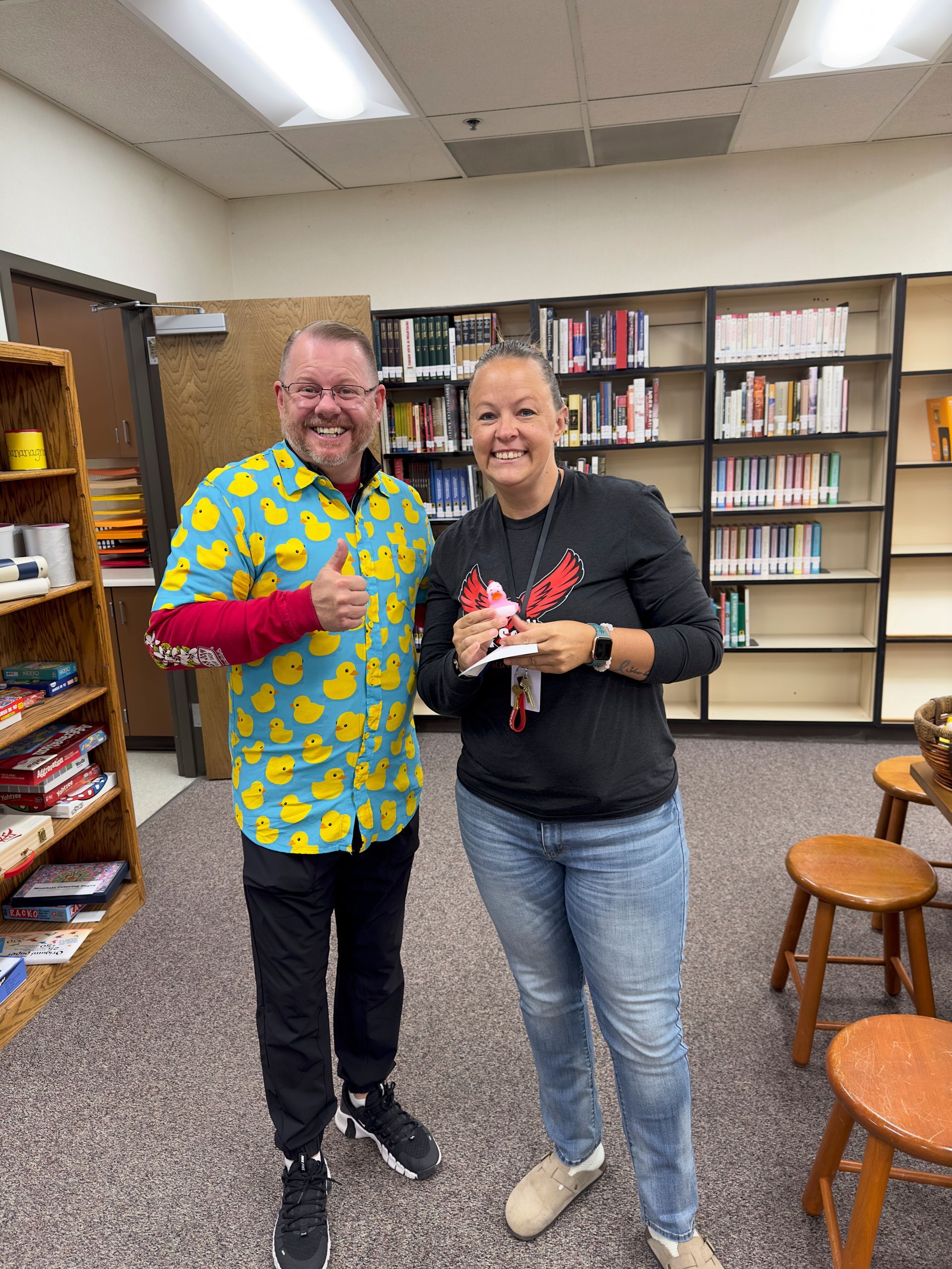 A man and a woman are standing next to each other in a library.