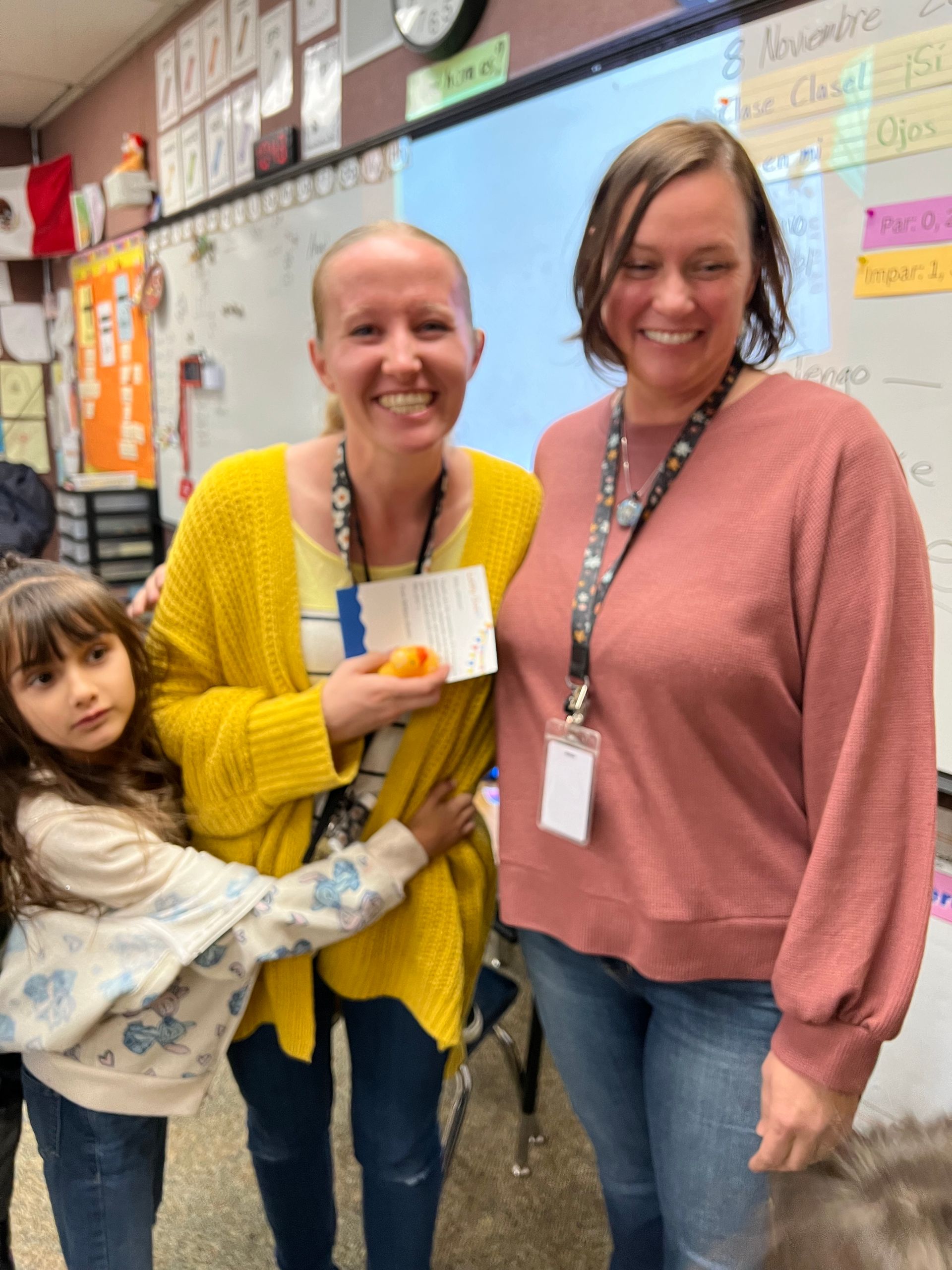 Two women are standing next to each other in a classroom.