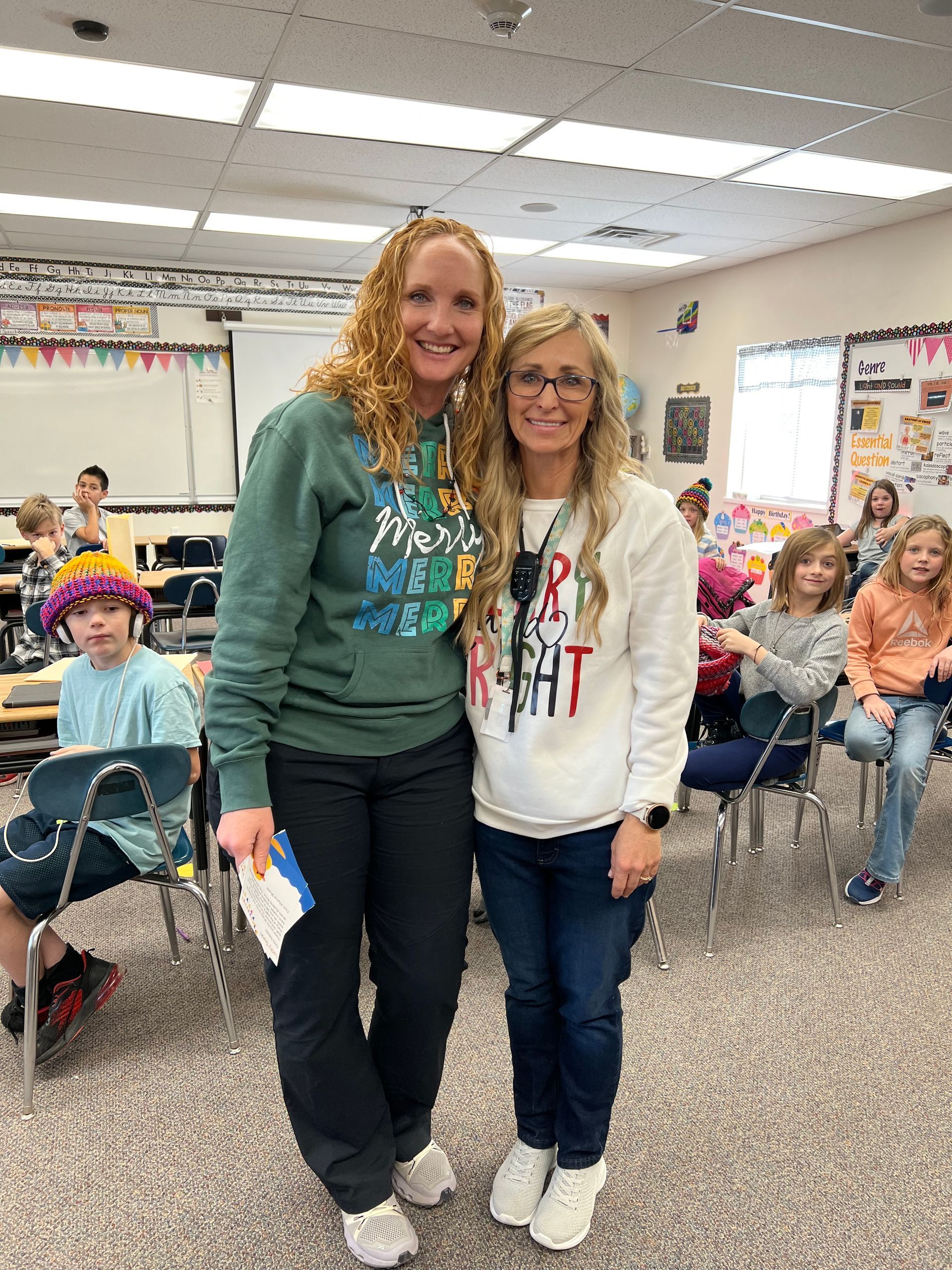 Two women are standing next to each other in a classroom.