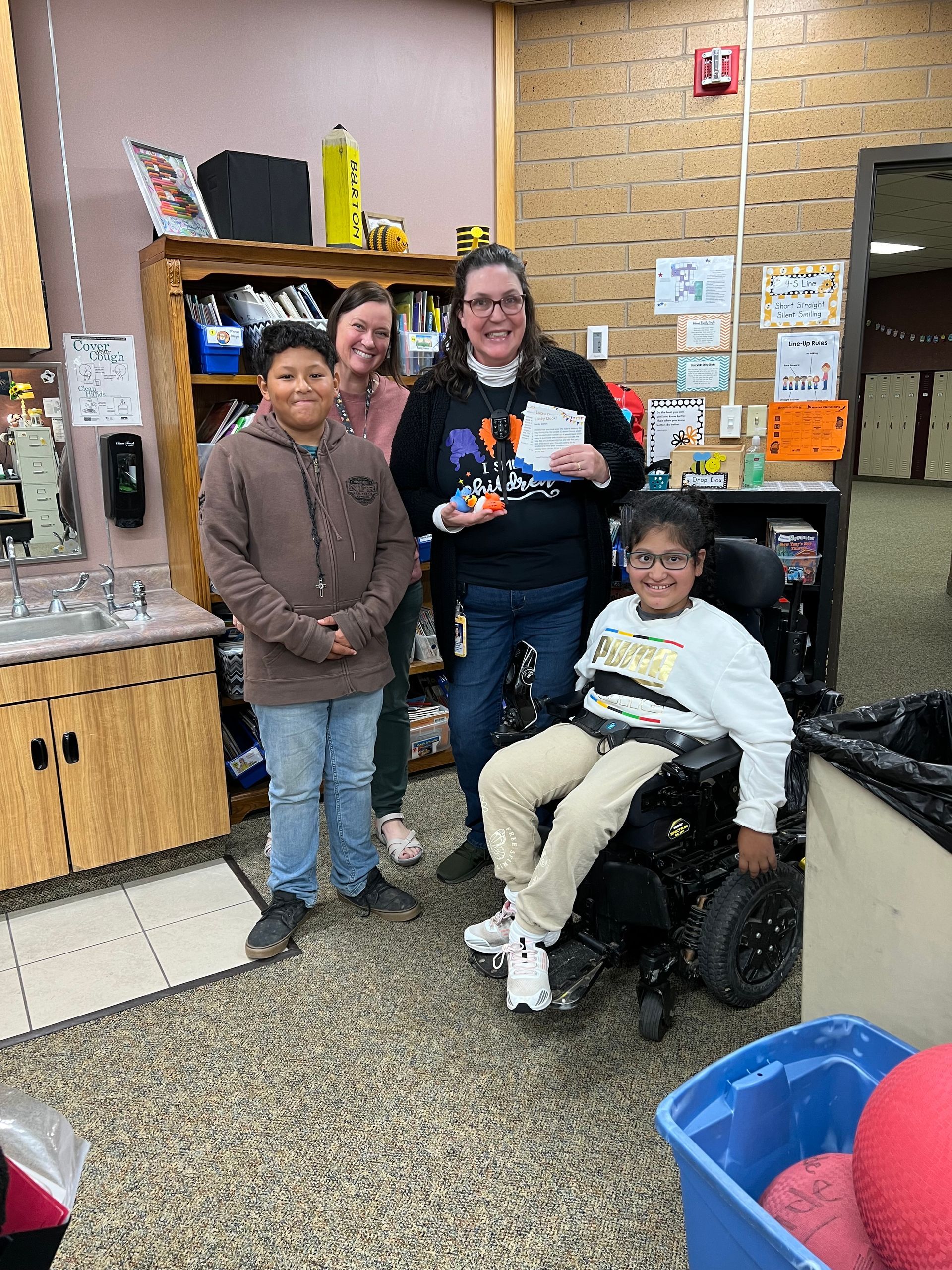 A group of people are standing around a boy in a wheelchair.