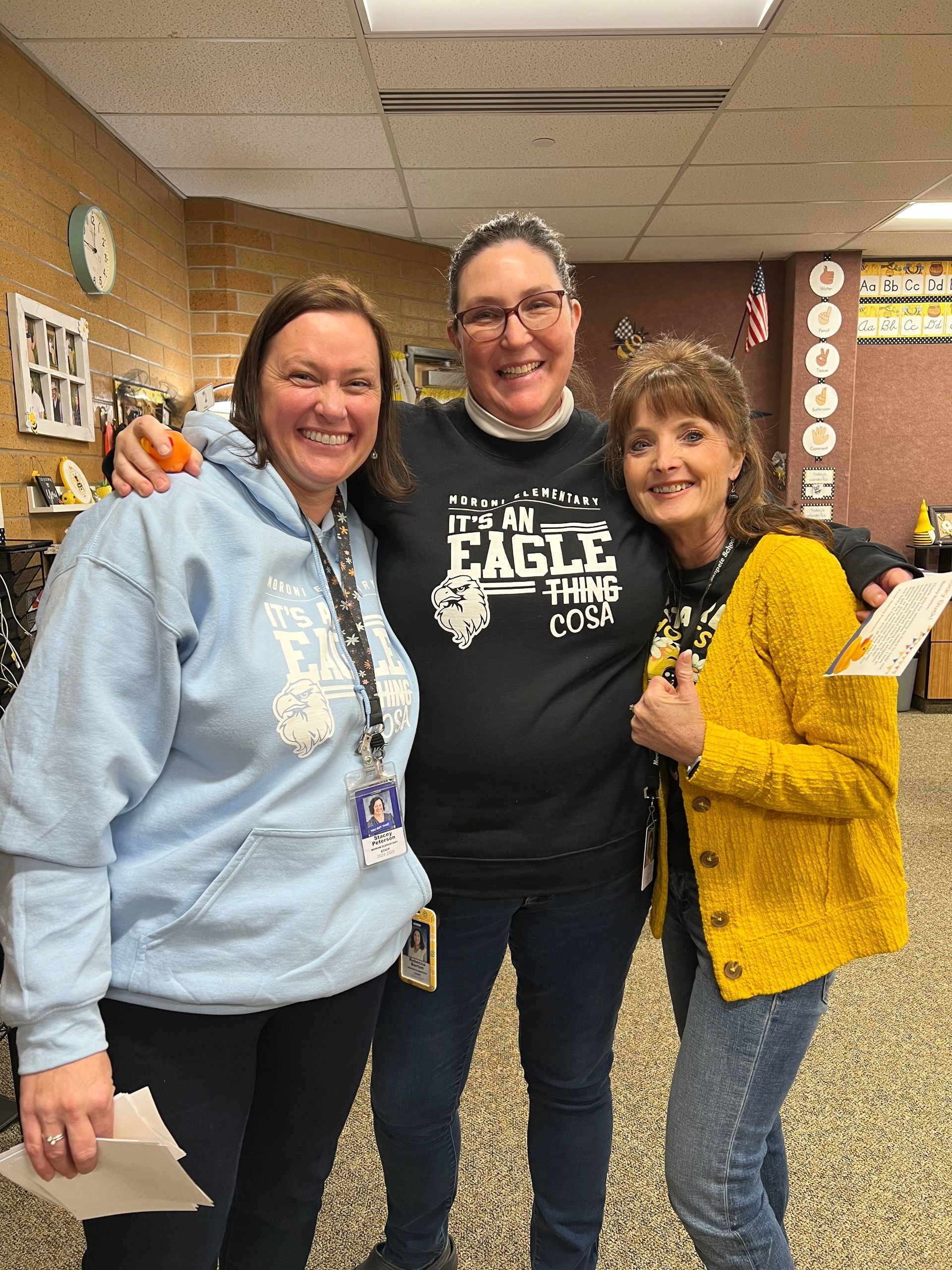 Three women are posing for a picture together in a room.