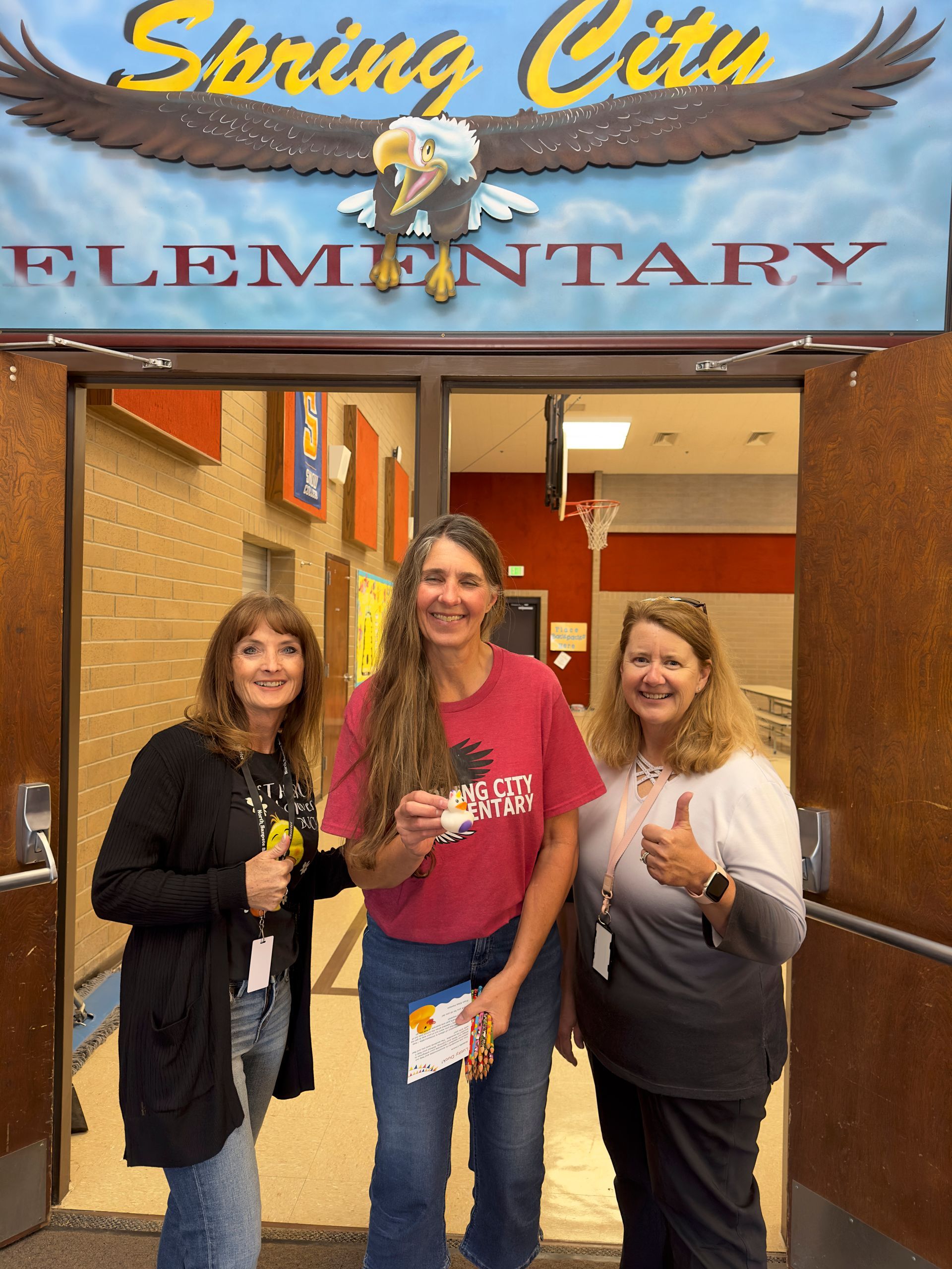 Three women are standing in front of a sign that says spring city elementary