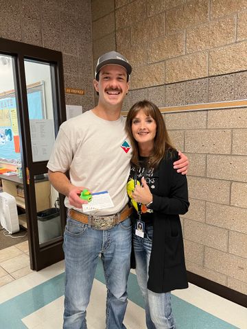 A man and a woman are posing for a picture in a hallway.