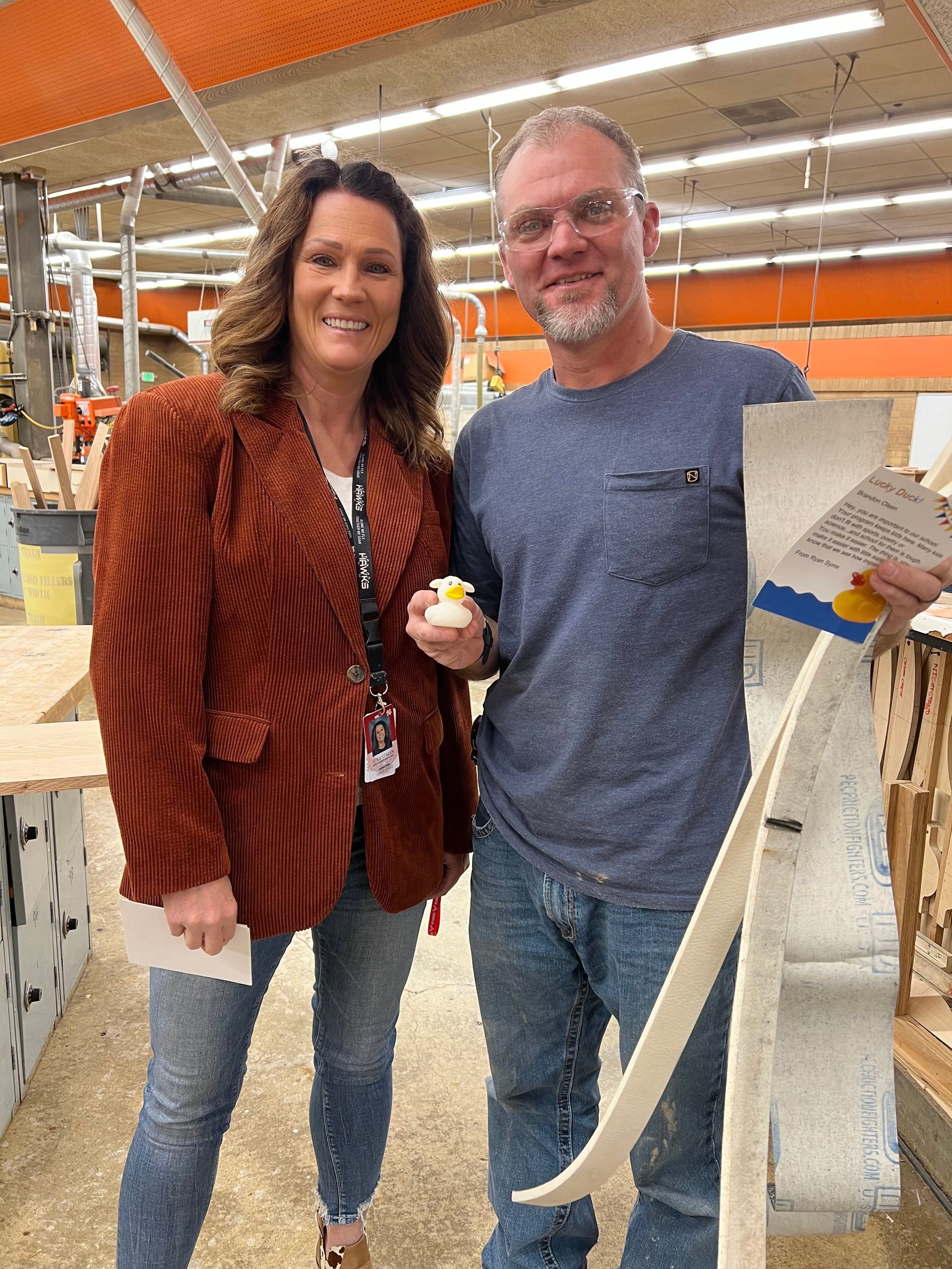 A man and a woman are standing next to each other in a factory.