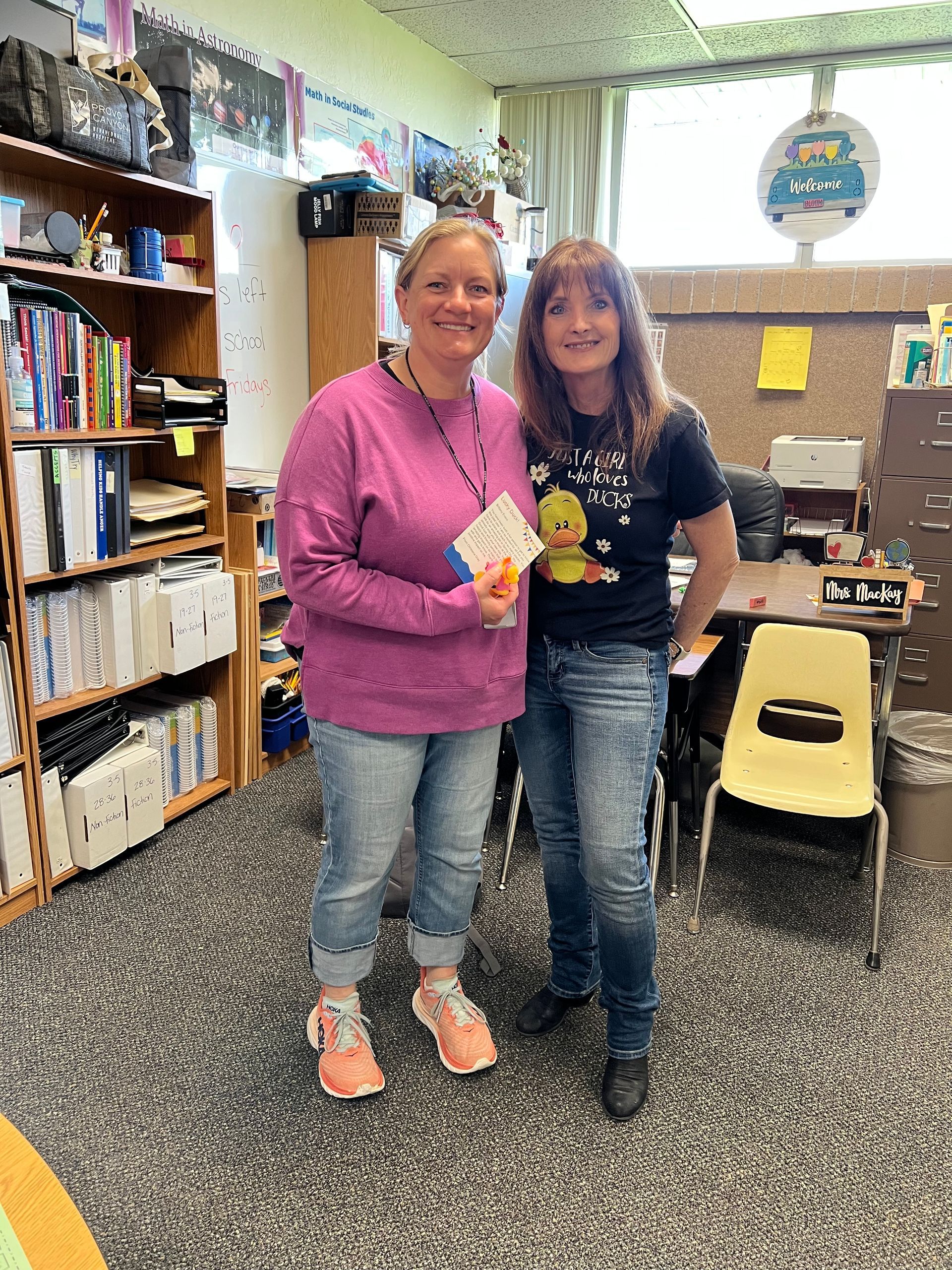 Two women are standing next to each other in a classroom.