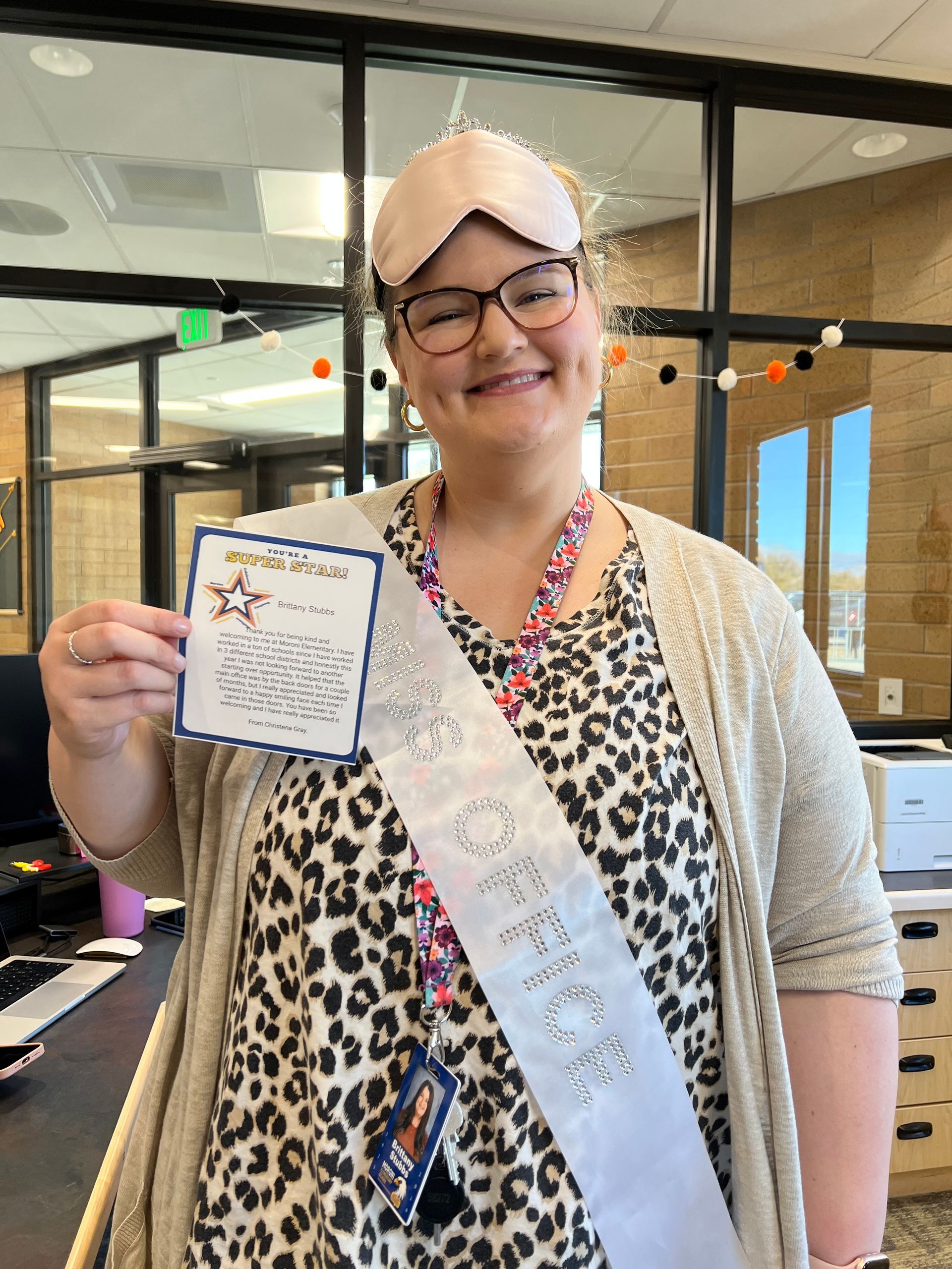 Woman wearing eye mask and sash that says 