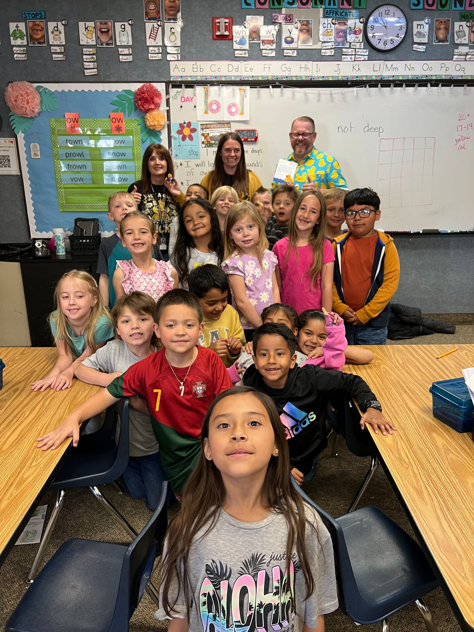 A group of children are posing for a picture in a classroom.