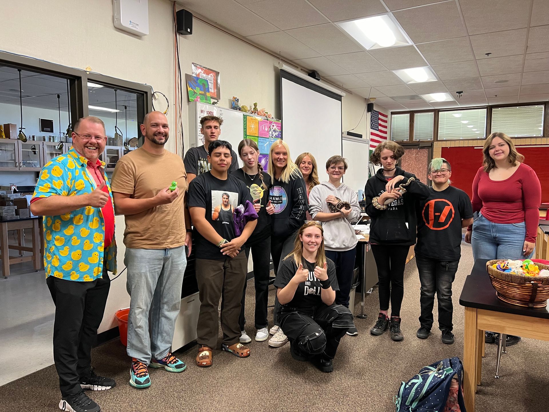 A group of people are posing for a picture in a classroom.