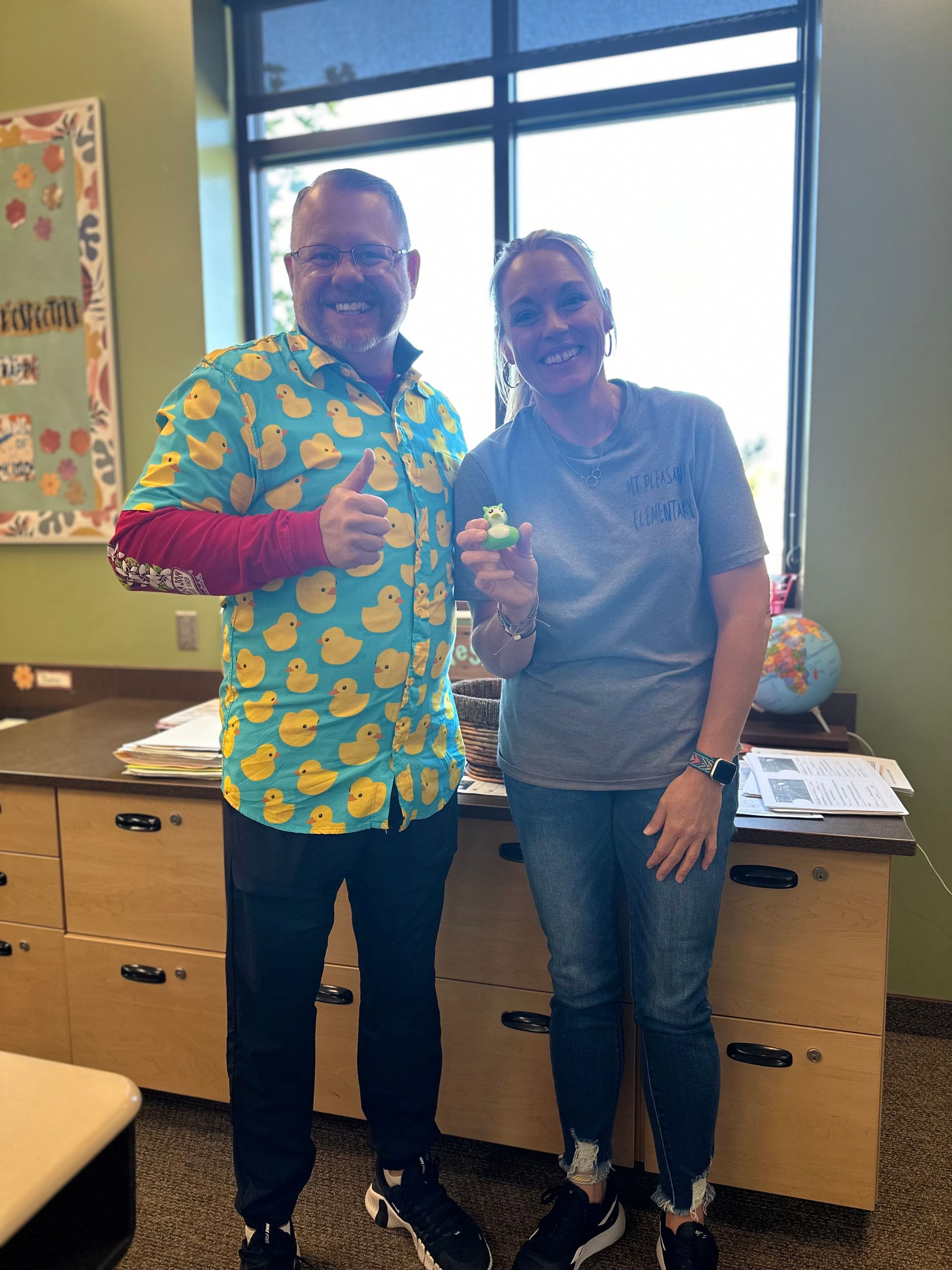 A man in a duck shirt is standing next to a woman