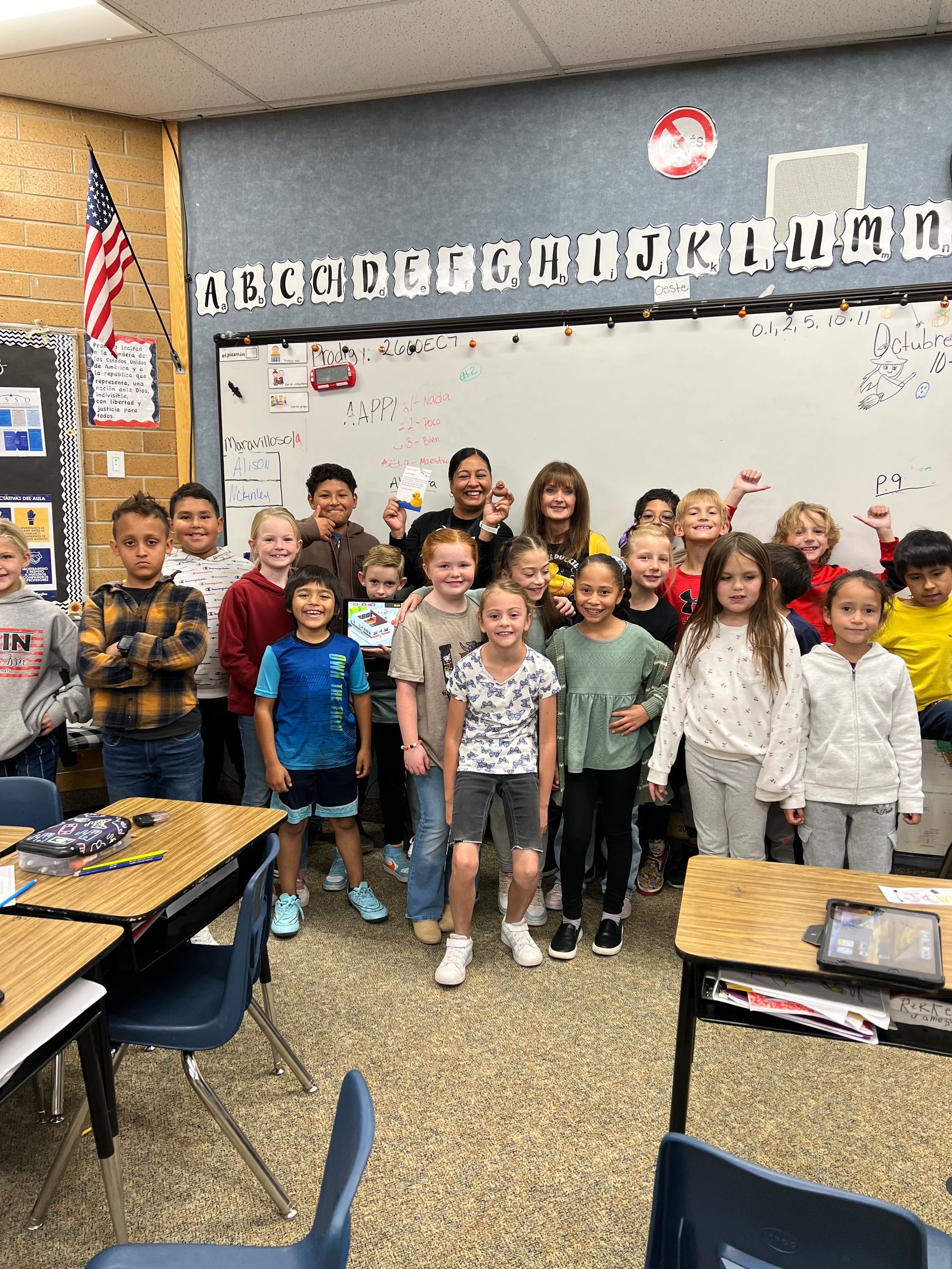 A group of children are posing for a picture in a classroom.