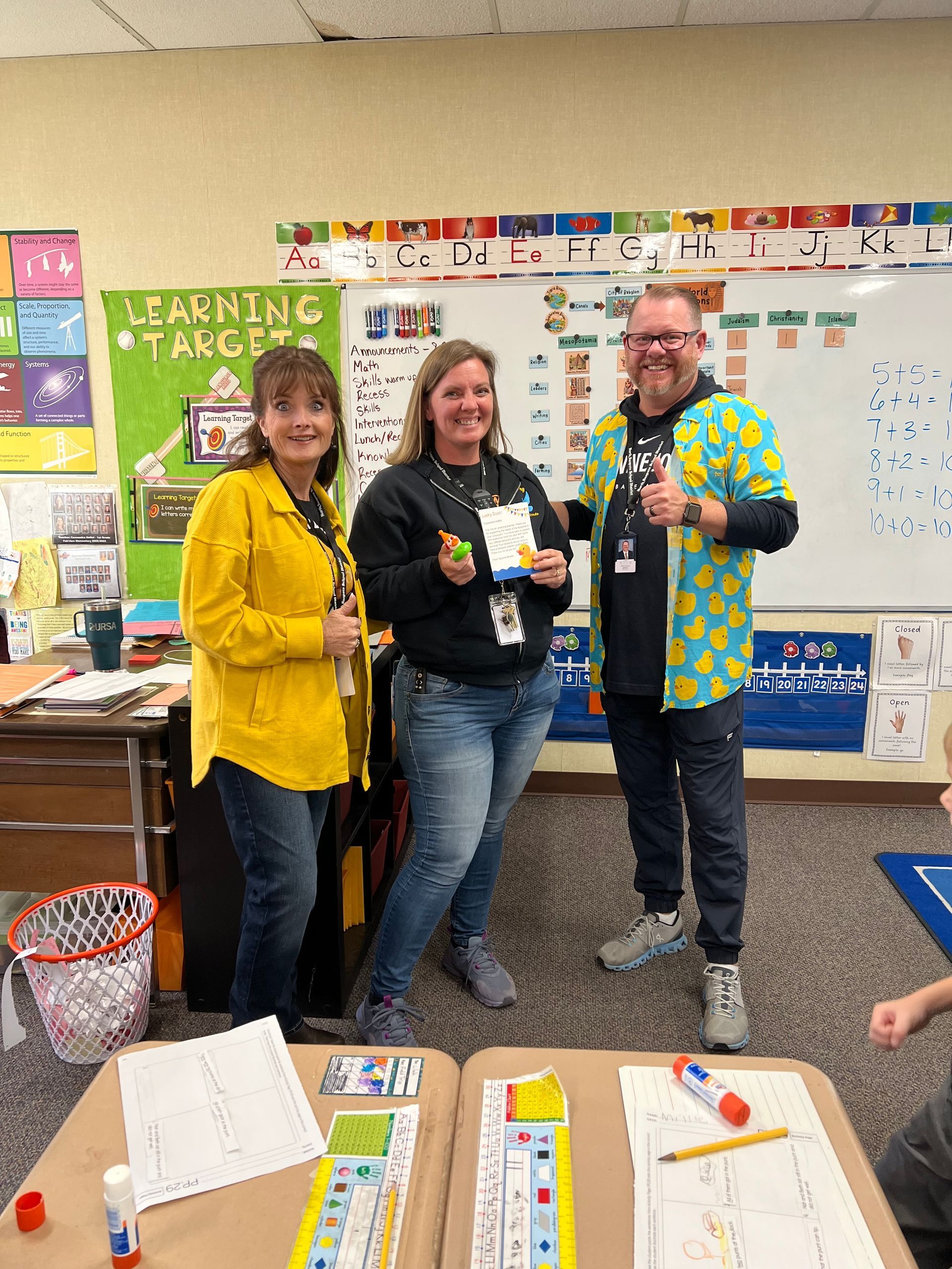 A group of people are standing in a classroom.