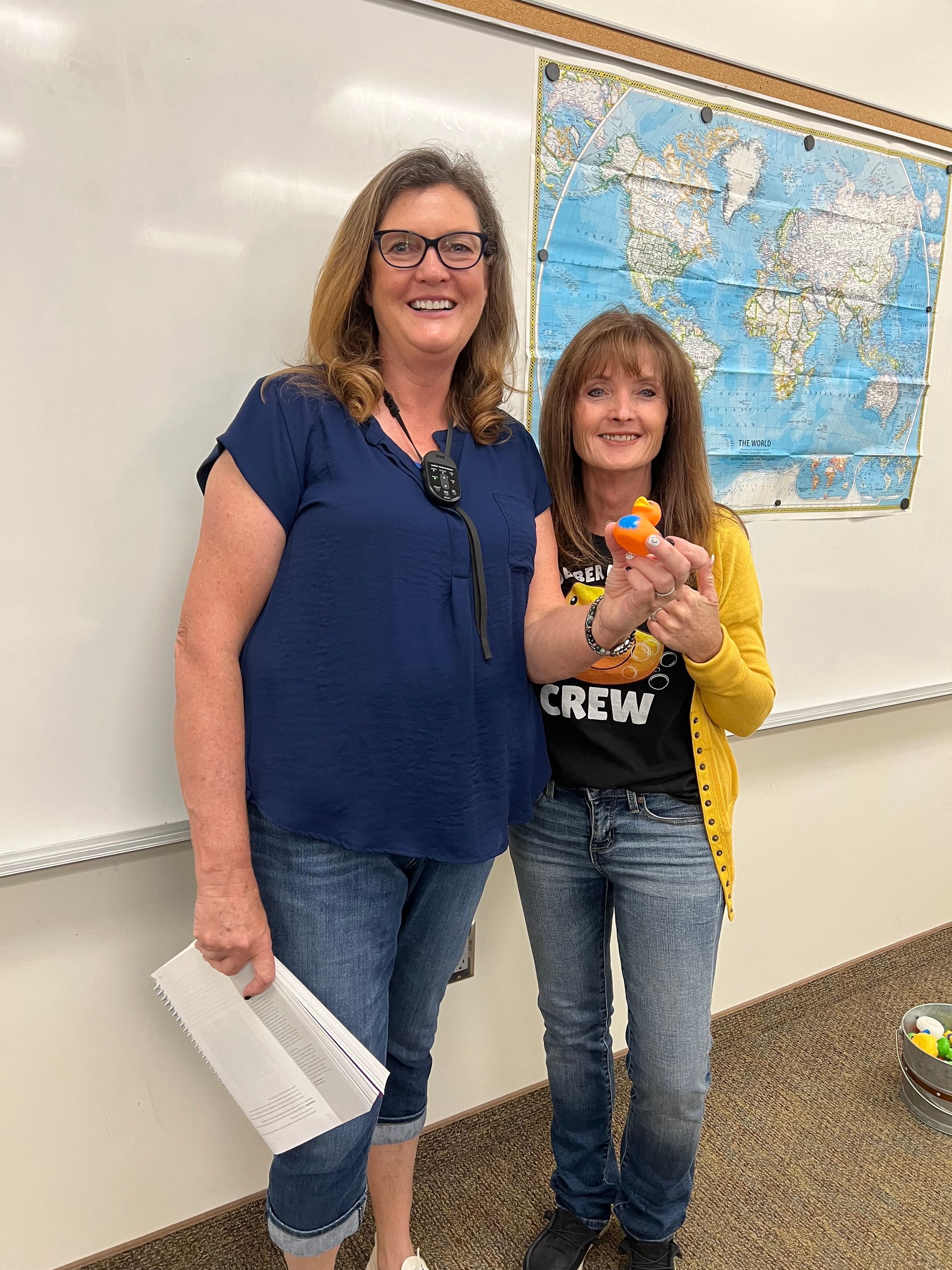 Two women are standing next to each other in a classroom.