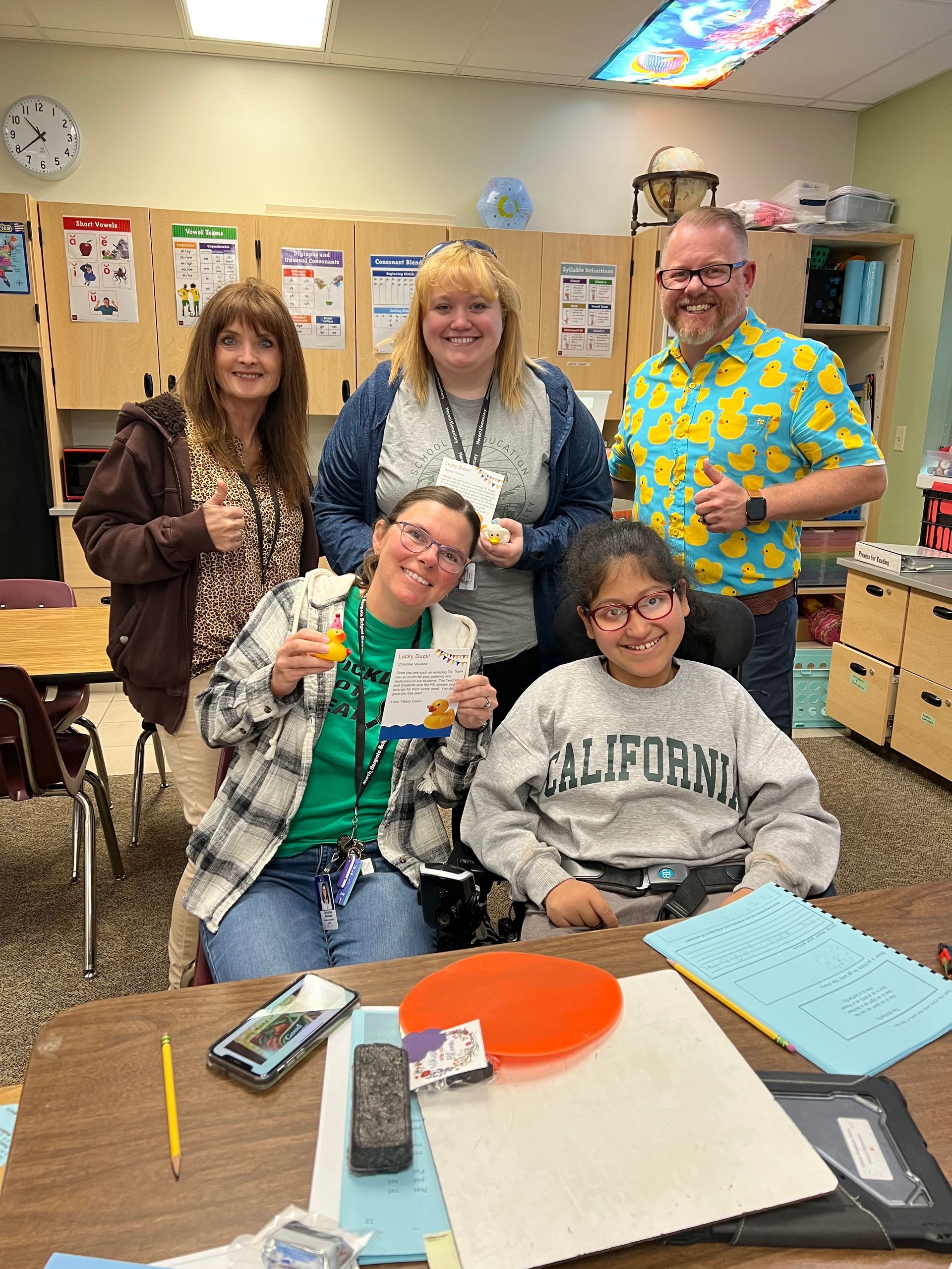 A group of people are posing for a picture in a classroom.
